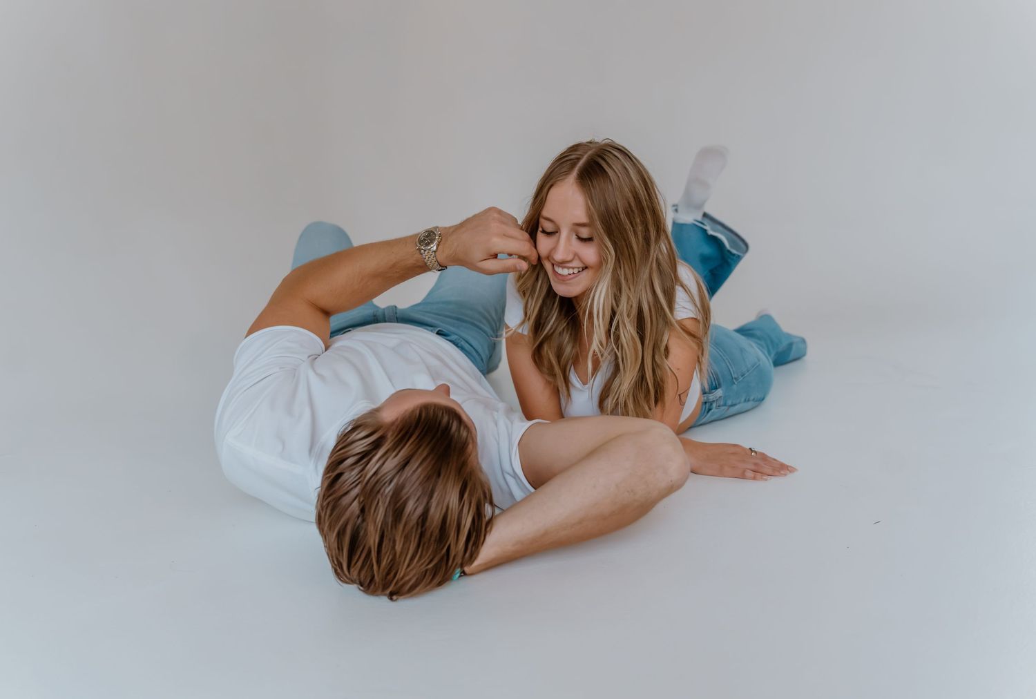 Couple sharing an intimate moment together on white background during photoshoot in Nashville, Tennessee.