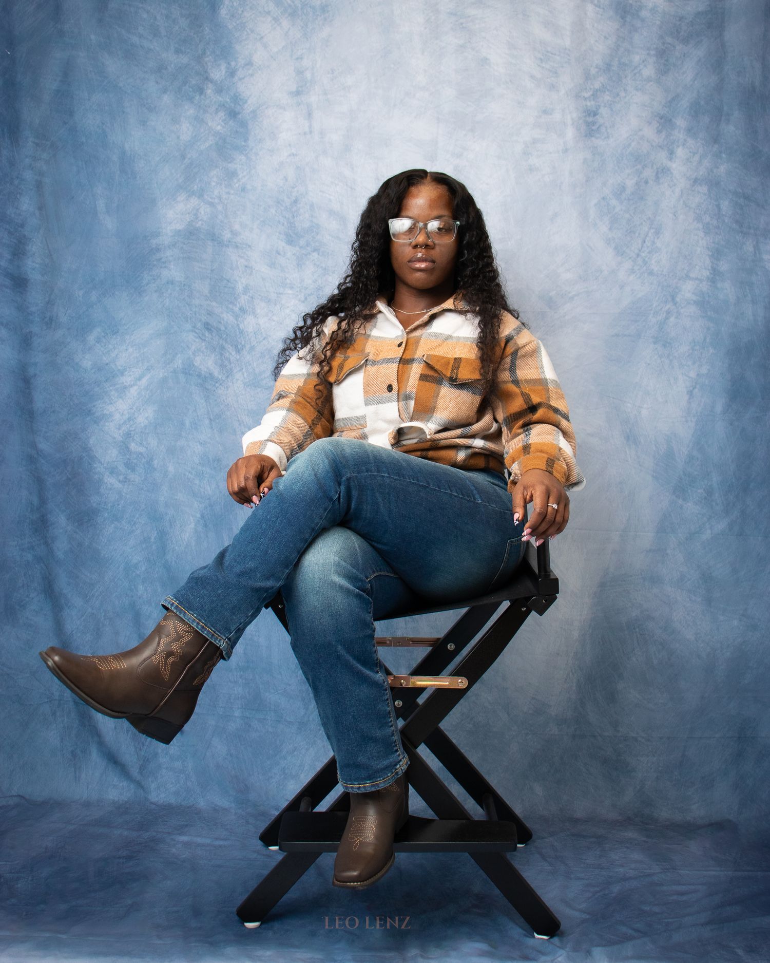 Studio fashion portraits showing denim and boots styling against textured blue backdrop.