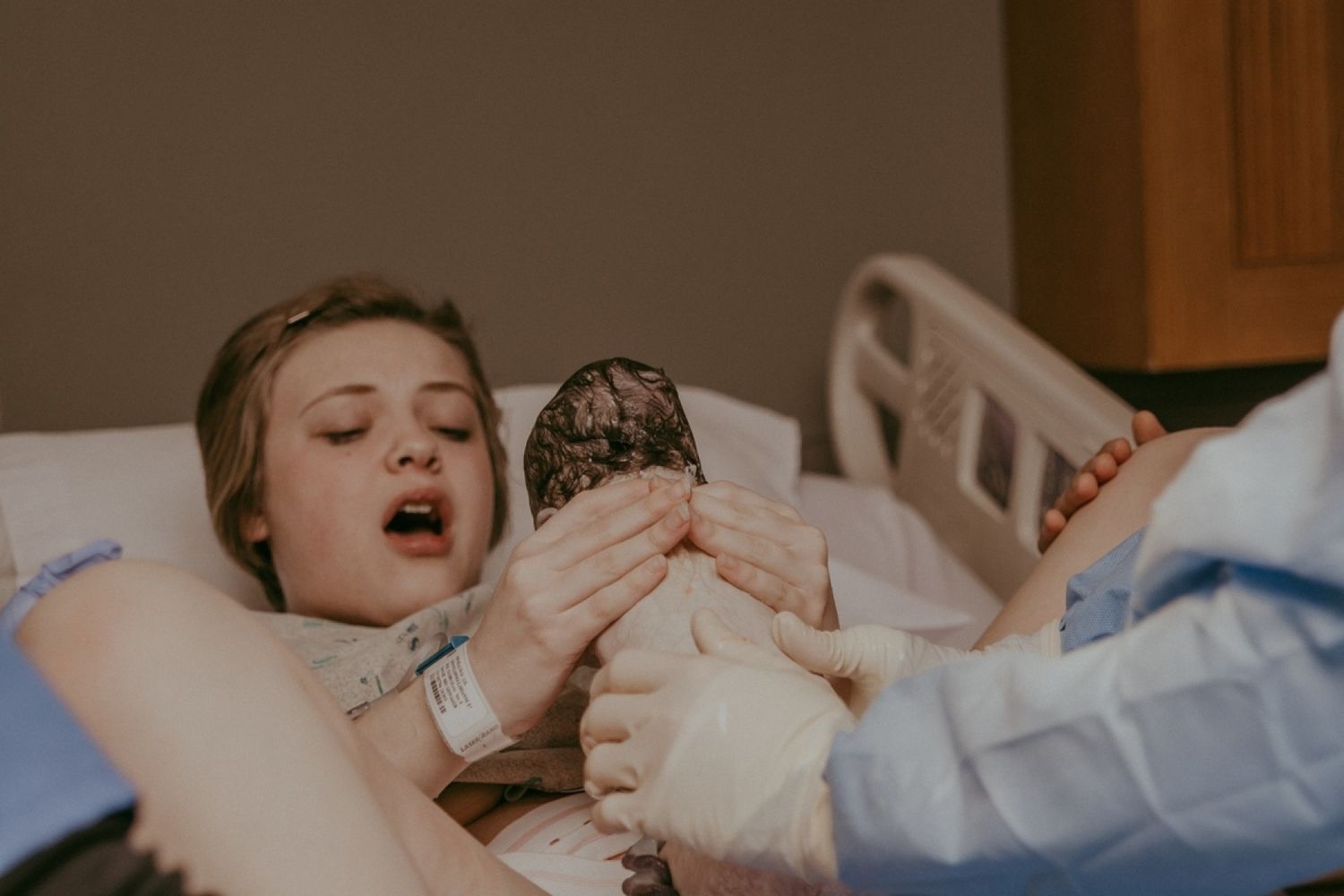 Medical procedure being performed in a clinical setting with gloved hands.