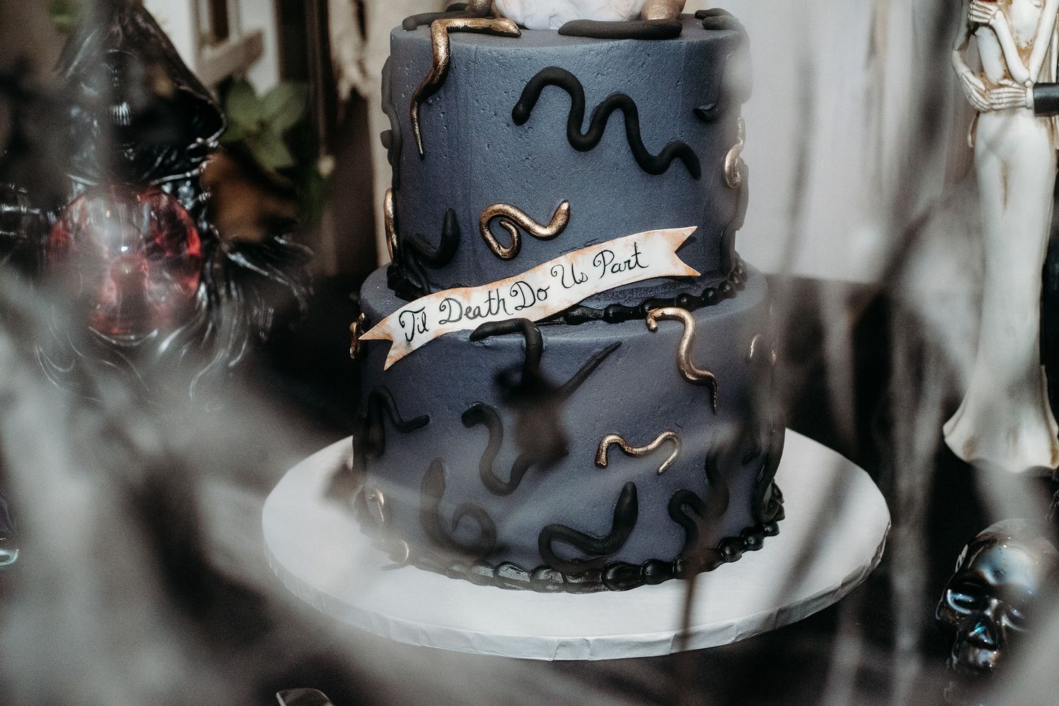 Dark moody wedding cake with abstract wavy designs on black fondant.