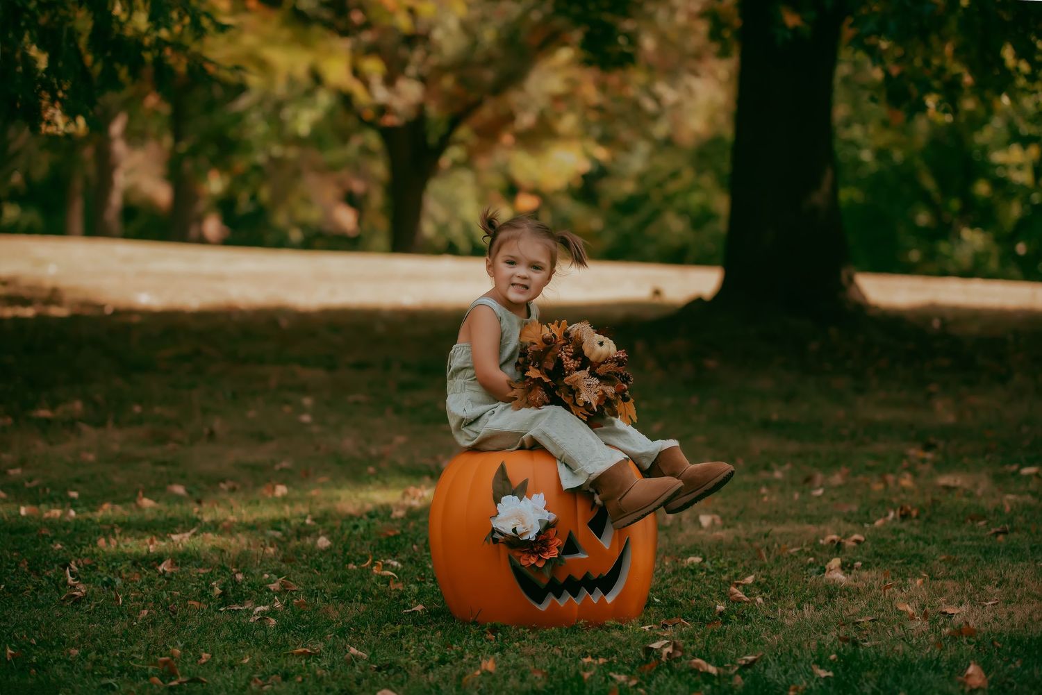 Orange pumpkins scattered on grass in a park setting.
