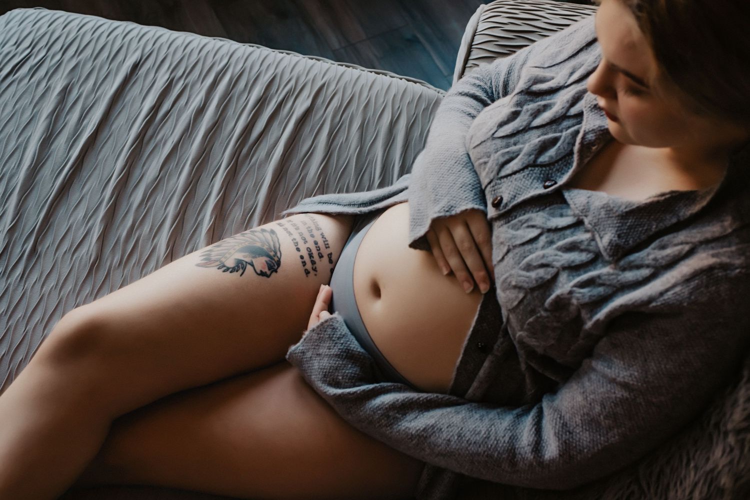 Intimate maternity photo showing pregnant belly in soft natural lighting.