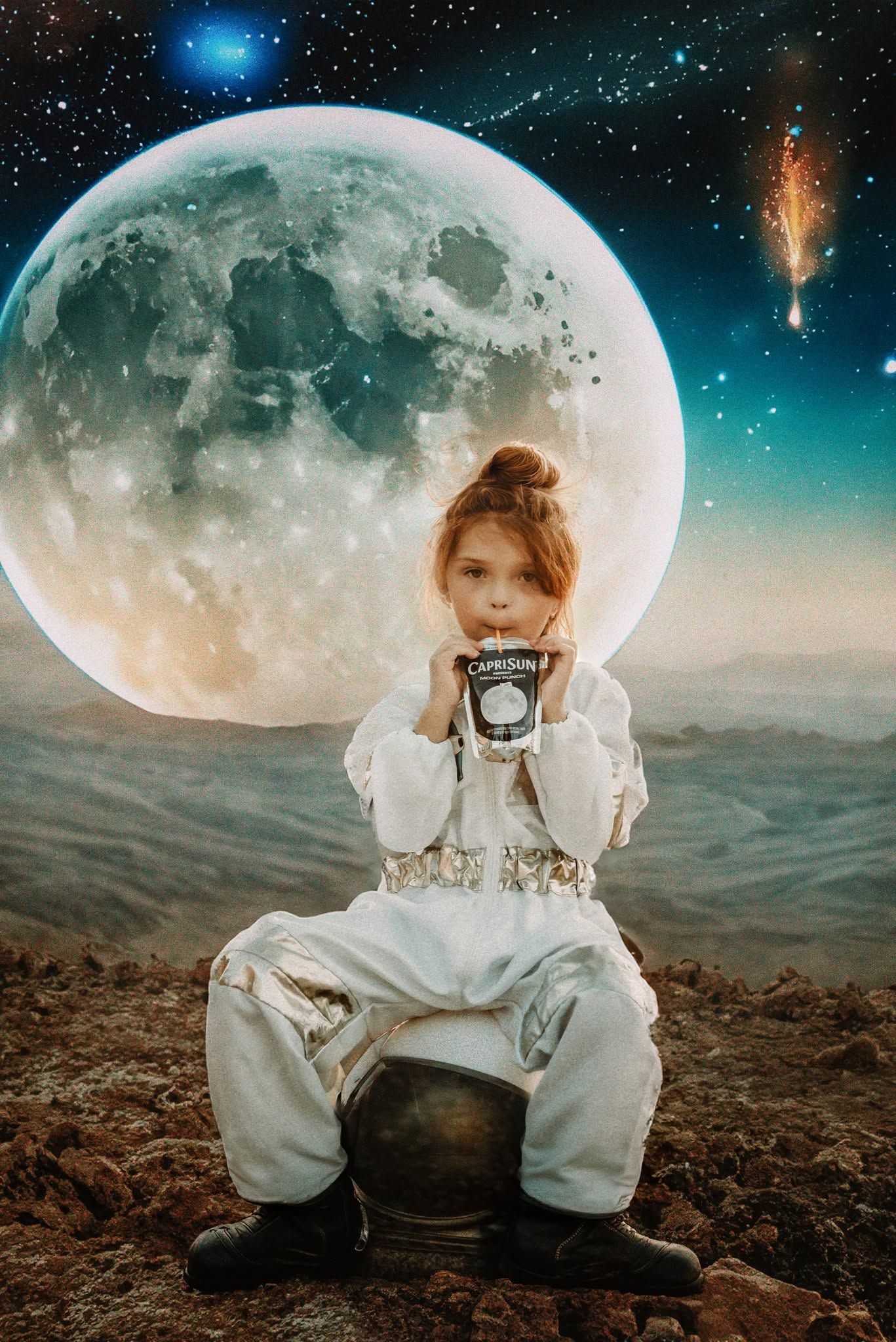 A young girl in an astronaut suit sits on a rocky surface, holding a Caprisun drink, with a large moon and stars behind her.