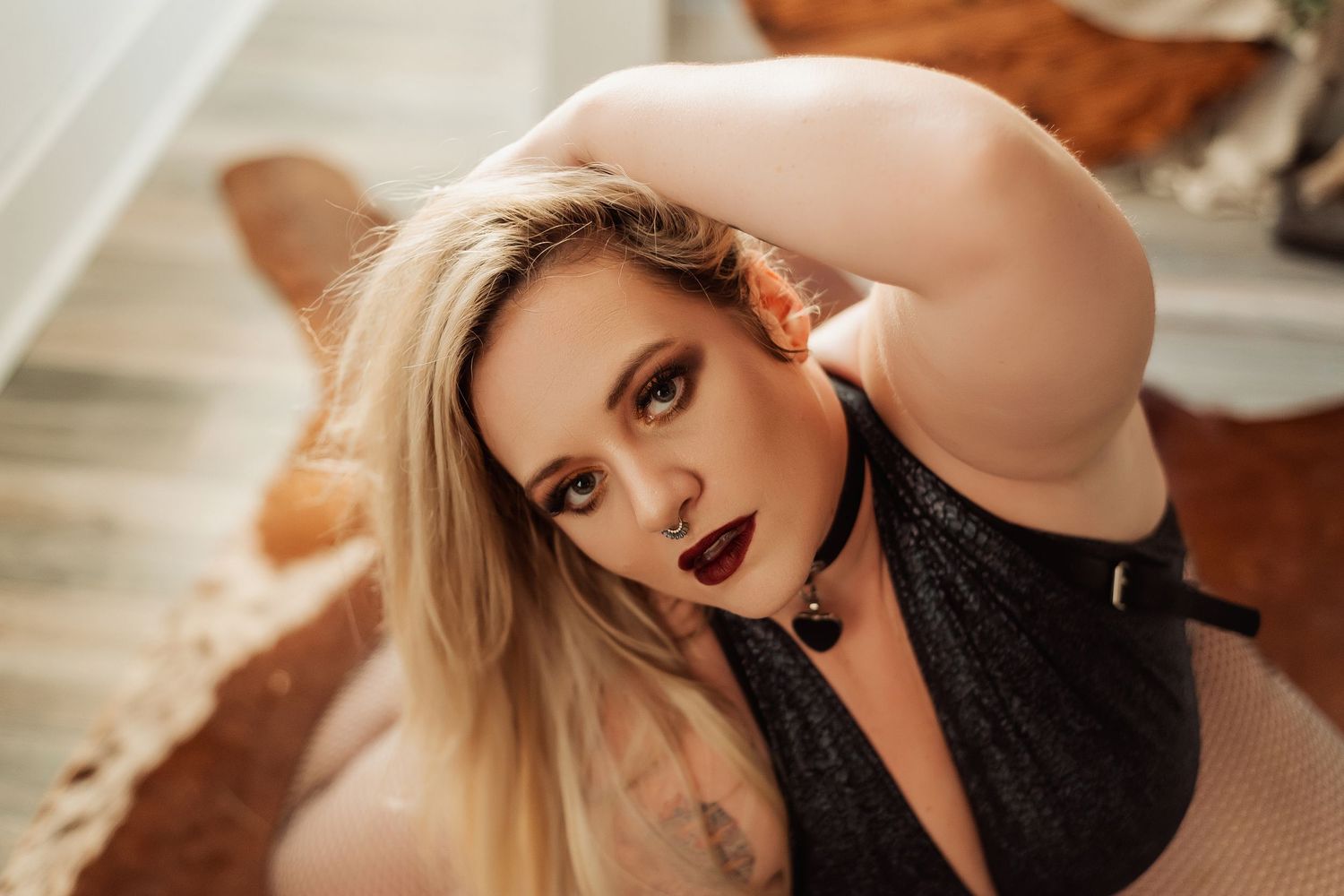Artistic boudoir portrait with dramatic lighting and glamorous styling.