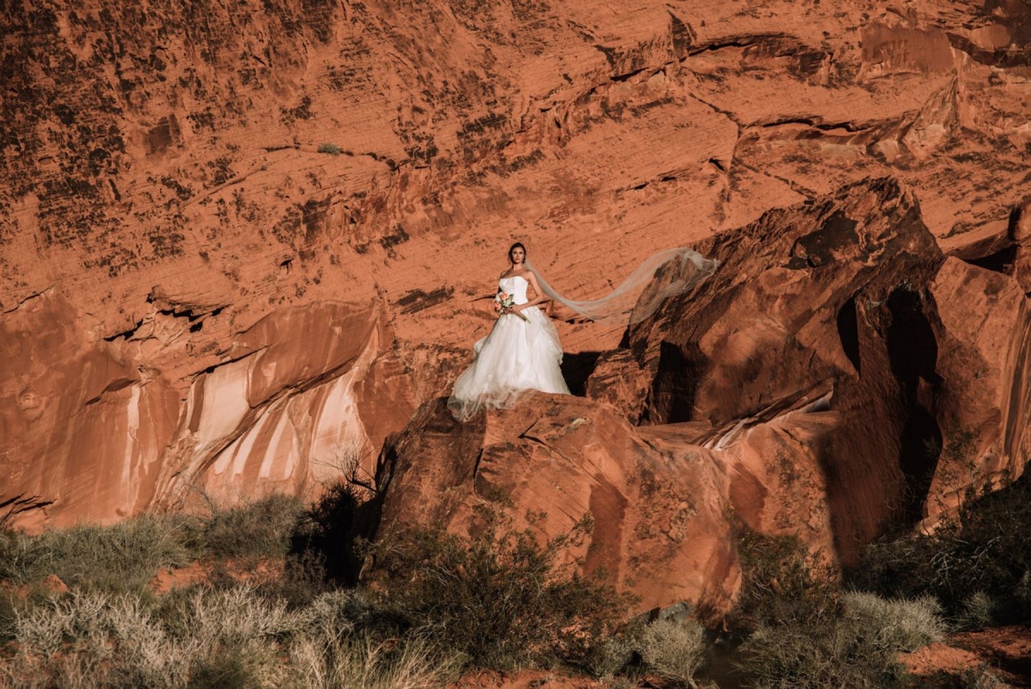Desert wedding photo session among dramatic red rock formations.