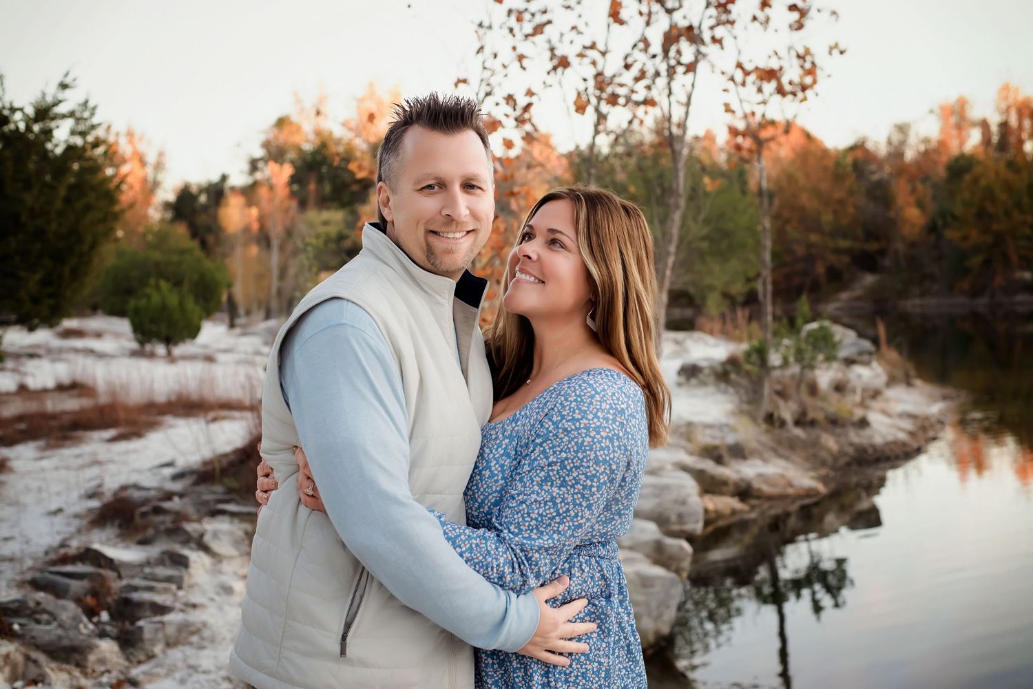 Romantic couple photos at sunset near a lake with natural autumn scenery.