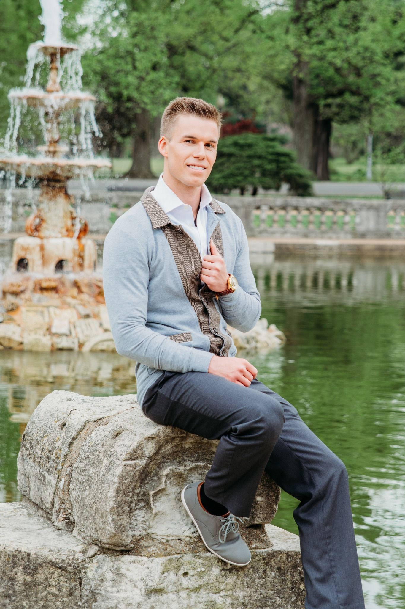 Senior portrait session by ornate fountain showing casual poses on stone wall.