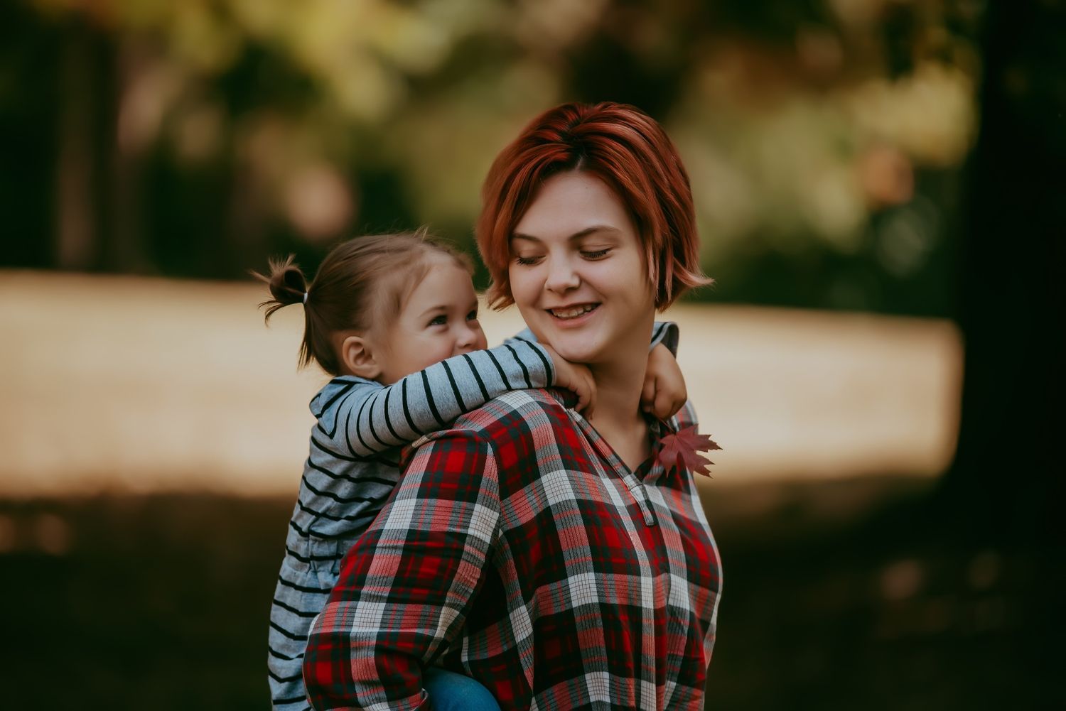 Playful outdoor moment with plaid shirt and striped clothing in warm sunlight.