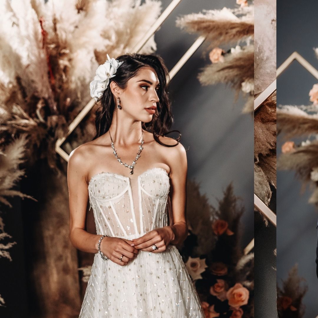 Elegant bride in white lace corset dress against dramatic brown and beige backdrop.