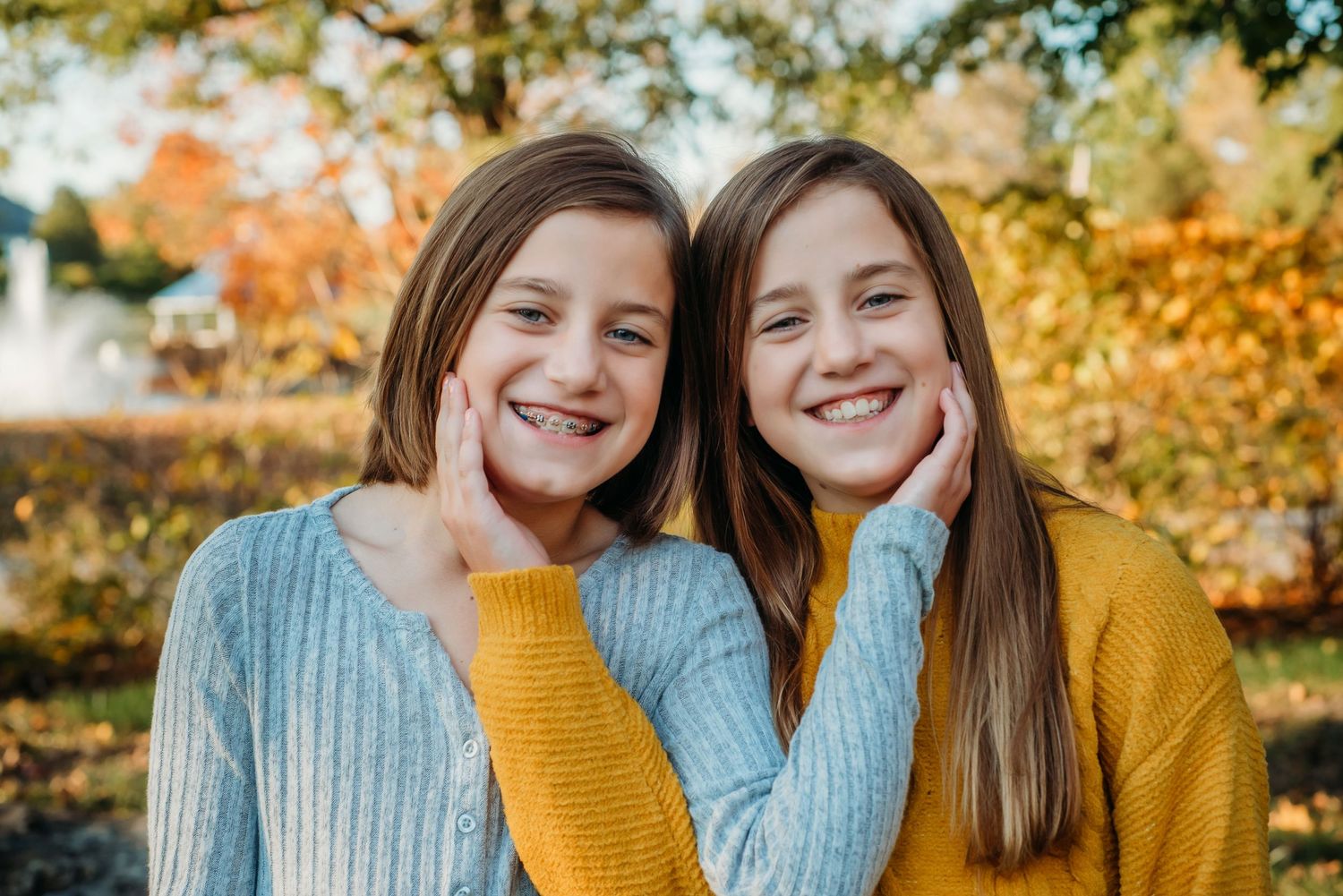 Young people in cozy sweaters smile together during fall photo session.