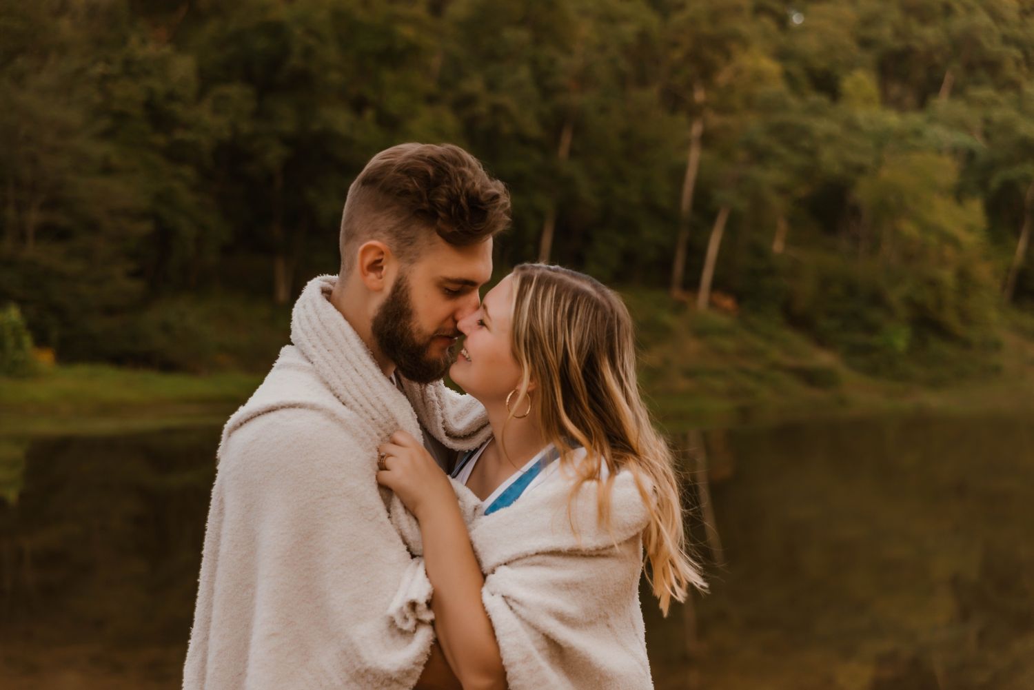 Intimate couple's portrait session at sunset near a lake.