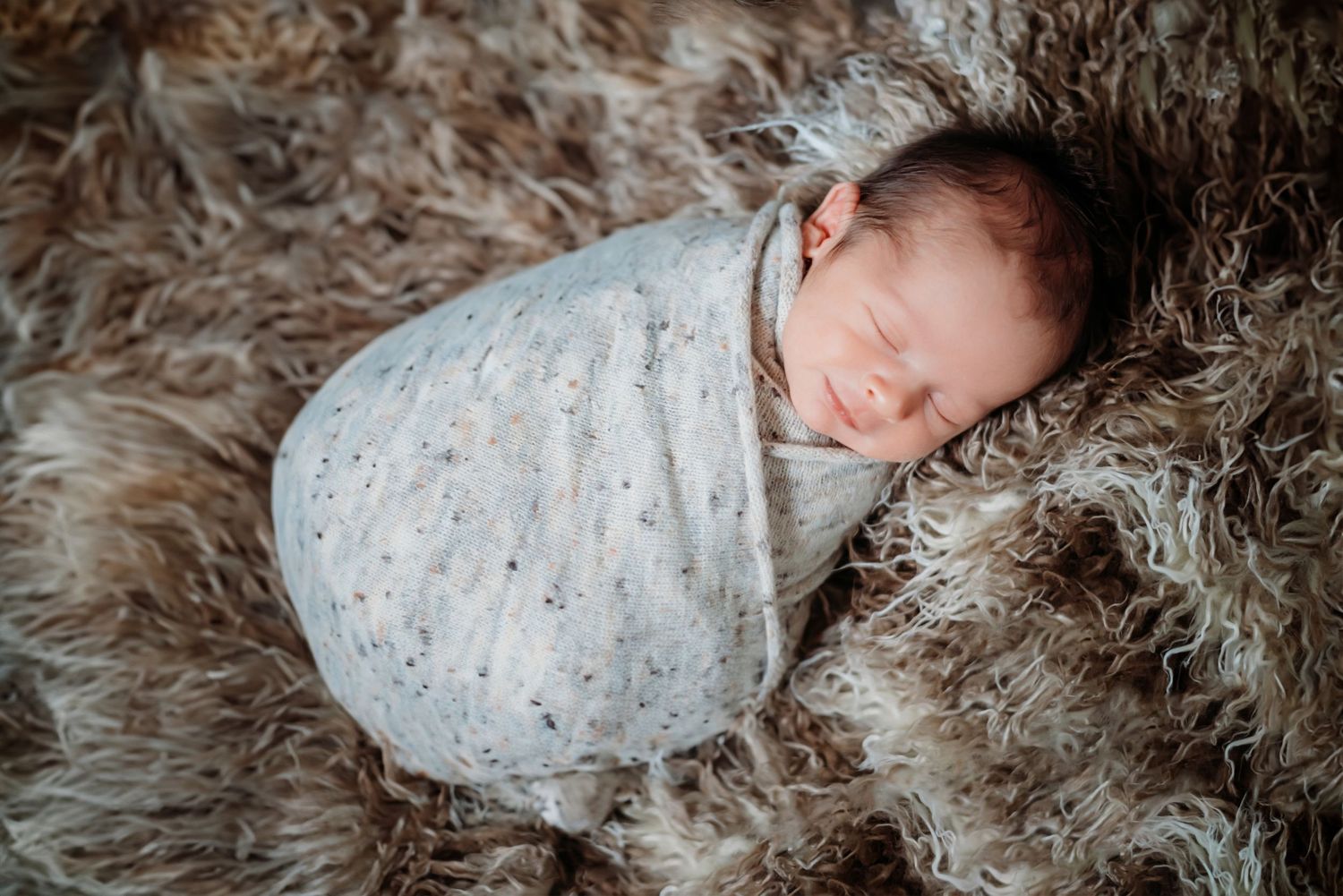 Intimate portrait session with soft lighting and textured fur blanket backdrop.