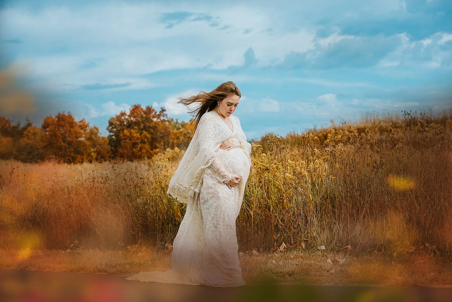 Ethereal outdoor photoshoot in a golden field during sunset.