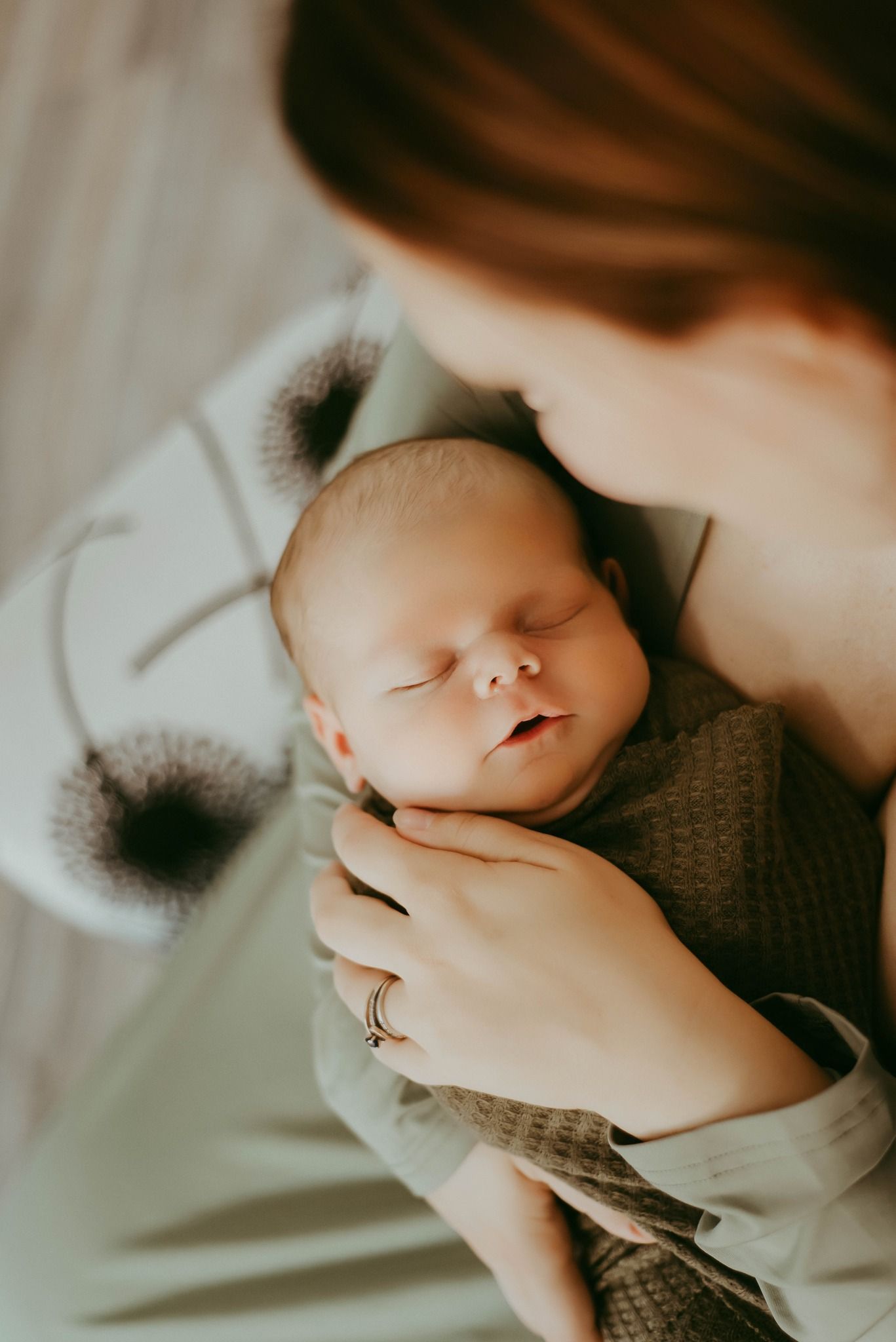 Peaceful sleeping baby wrapped in cozy blanket with gentle parental touch.