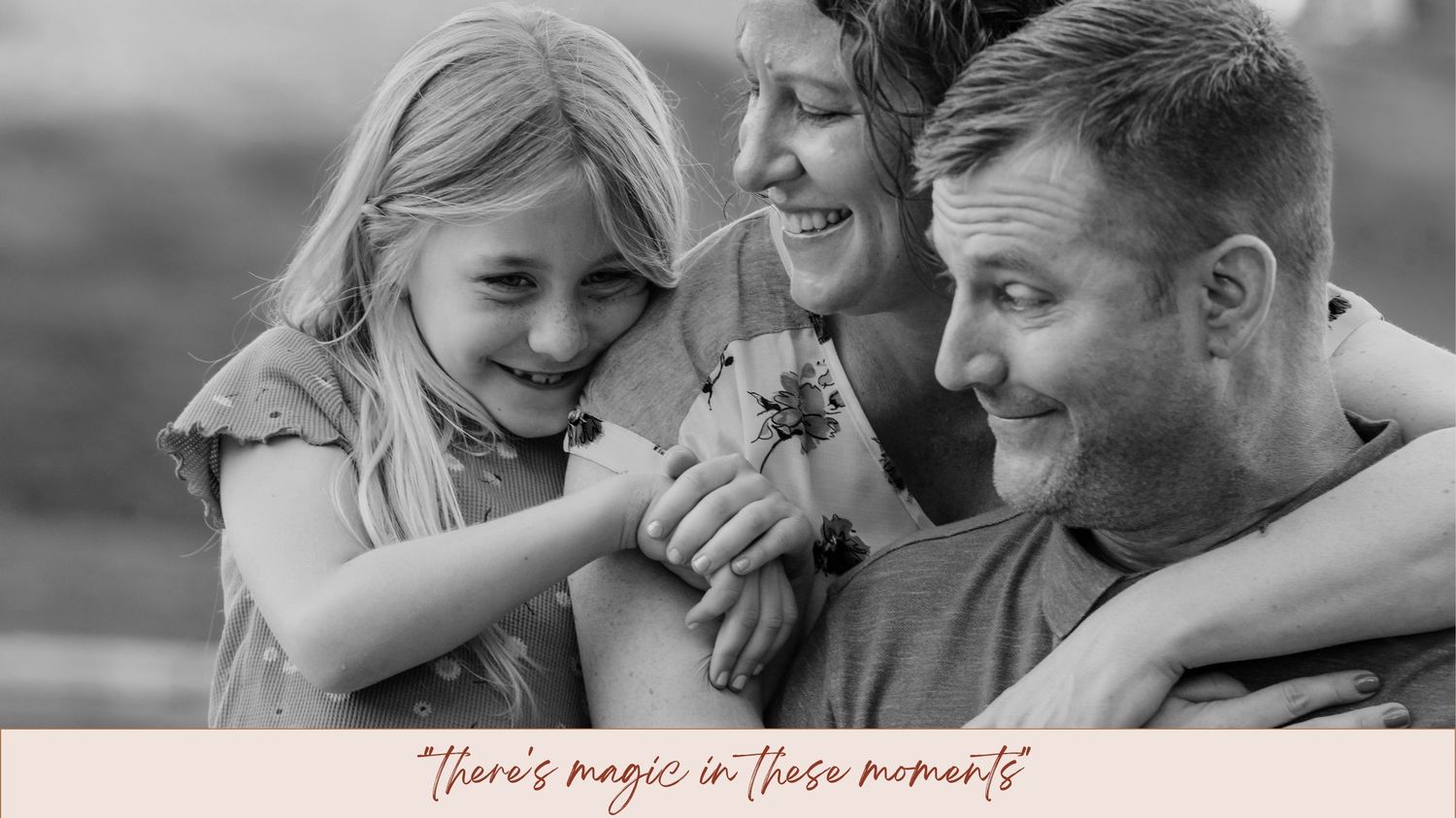 Black and white family photo of parents and daughter laughing together with text 'there's magic in these moments'.