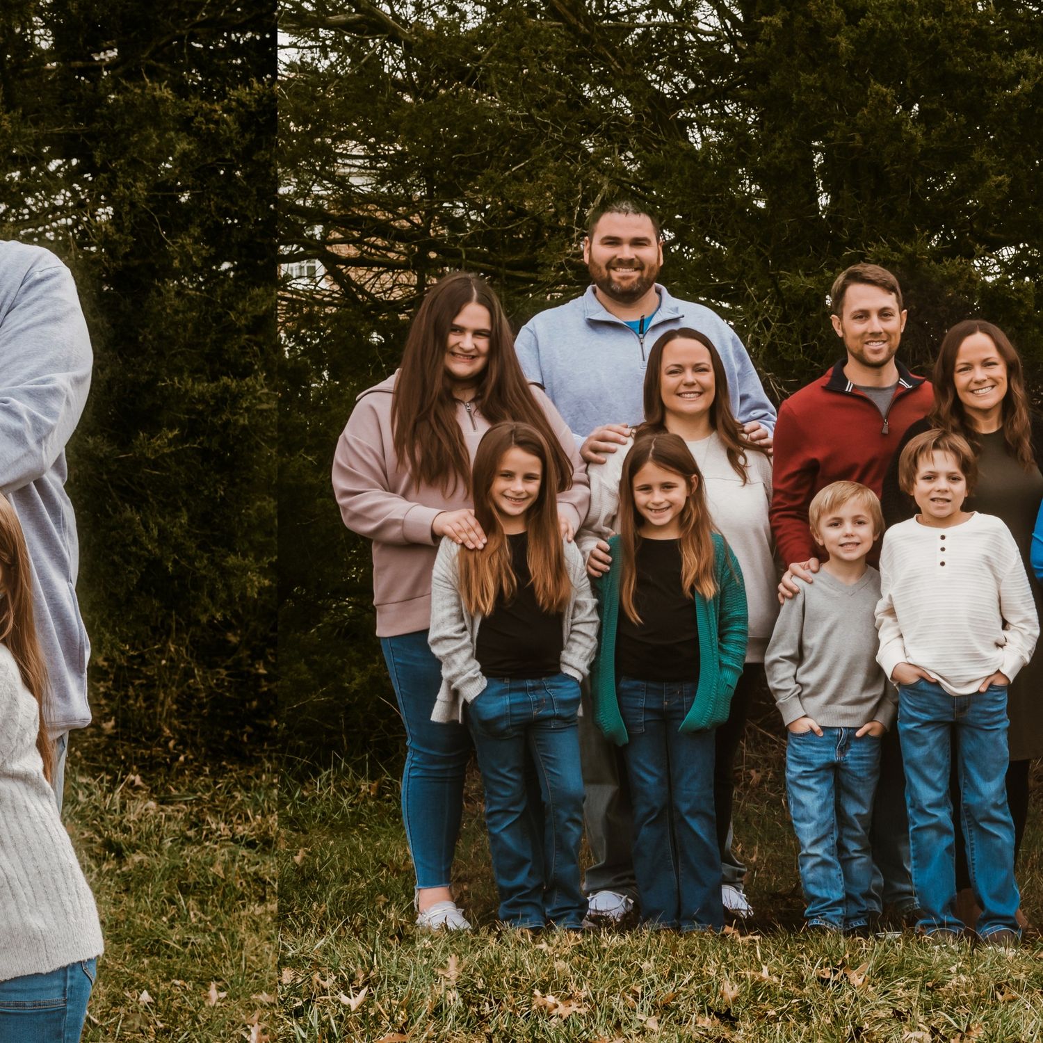 Extended family group poses together on grassy hill wearing coordinated casual outfits.