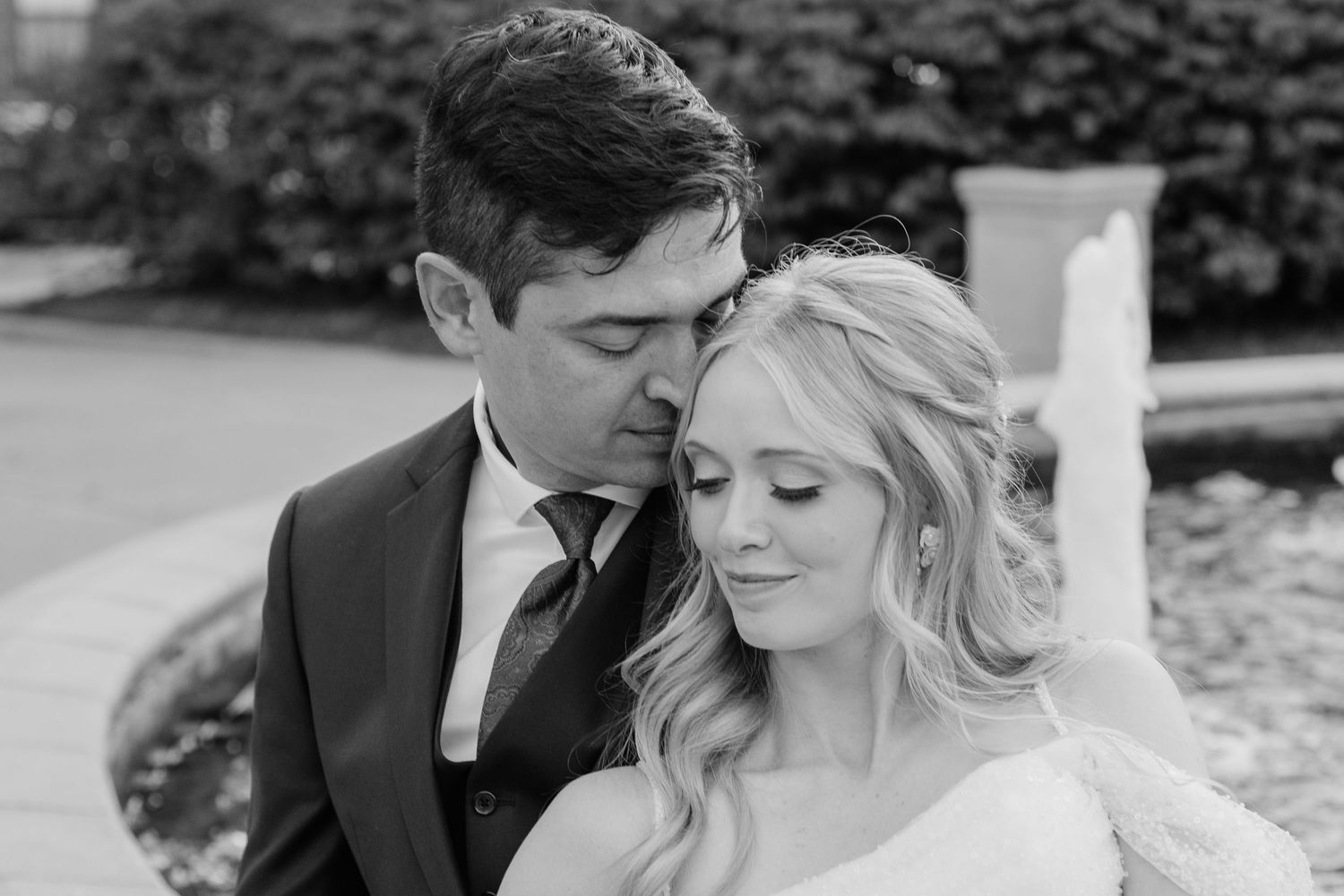 Romantic wedding couple embracing in black and white photography.