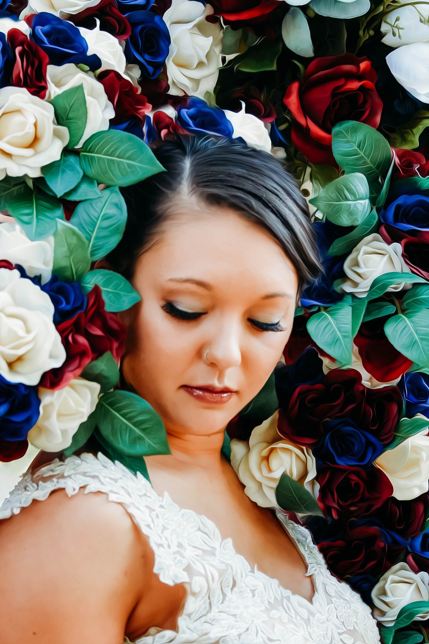 Red, white and blue roses create a lush floral backdrop with green leaves.