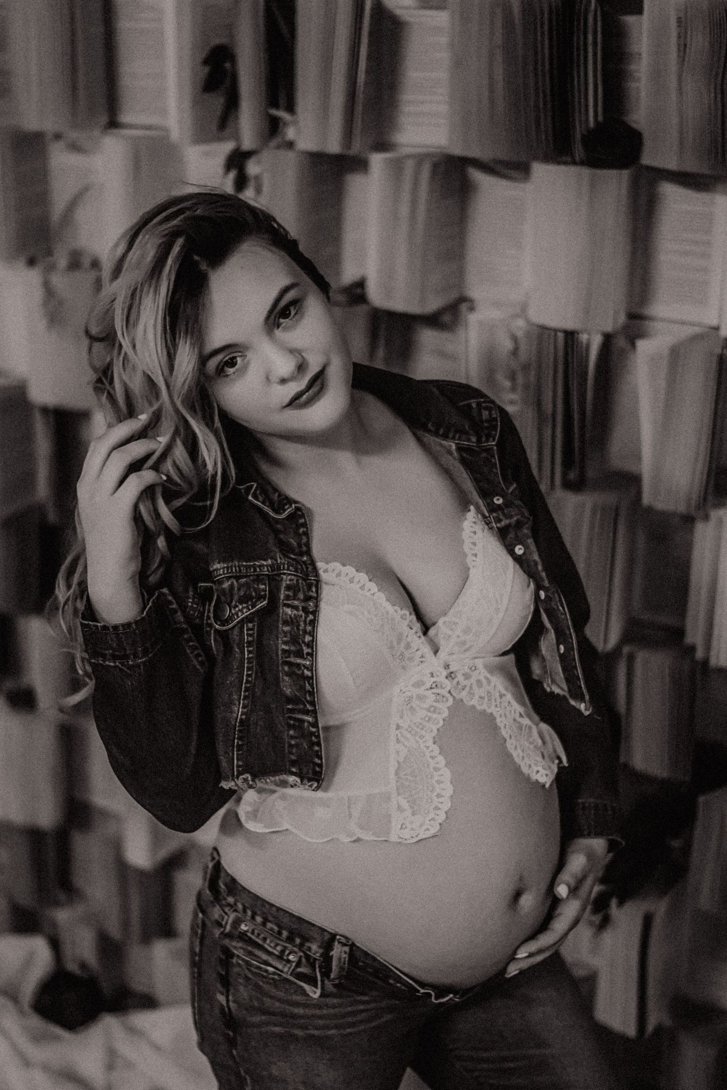 Black and white boudoir photo series showing a woman in a denim jacket and lace top posing against a curtained backdrop.