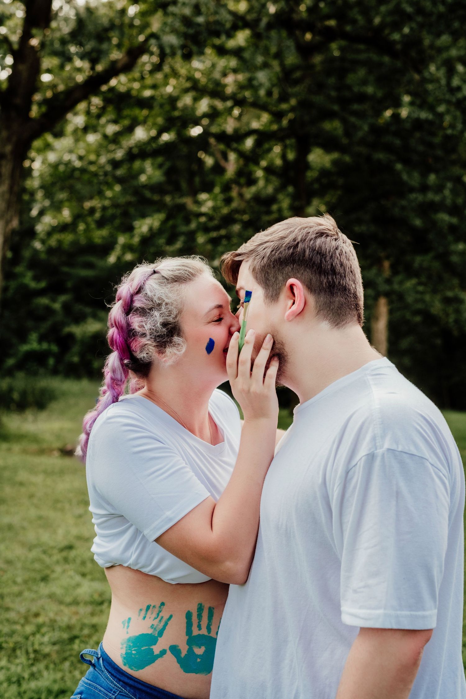 An intimate moment between a couple with painted faces in an outdoor setting.