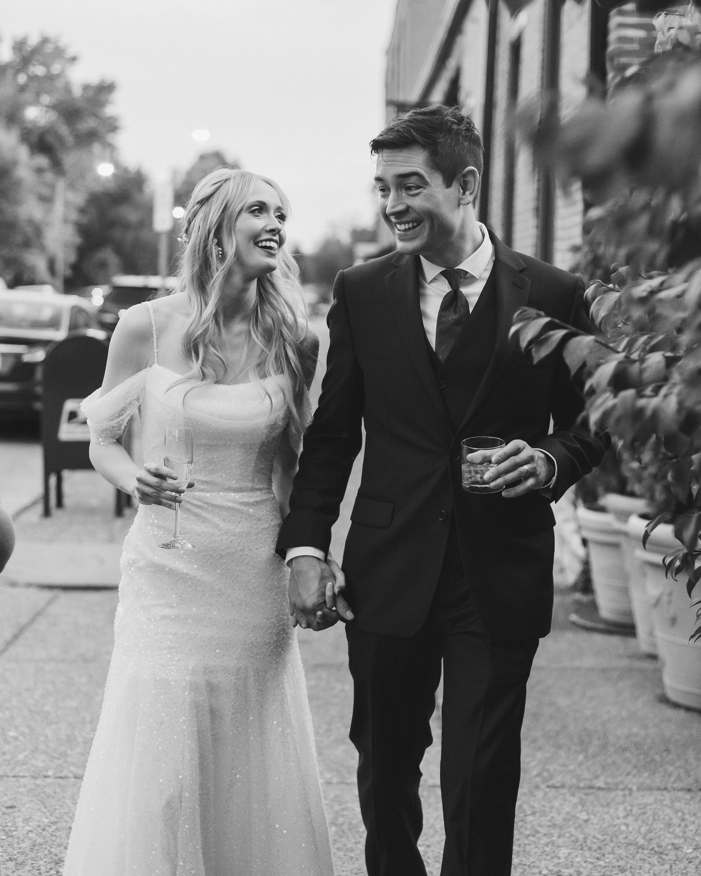 Candid black and white wedding photos showing joyful moments between newlyweds walking together.