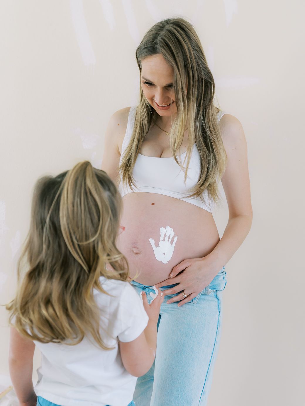 Intimate maternity photography session showing tender moments between family members.