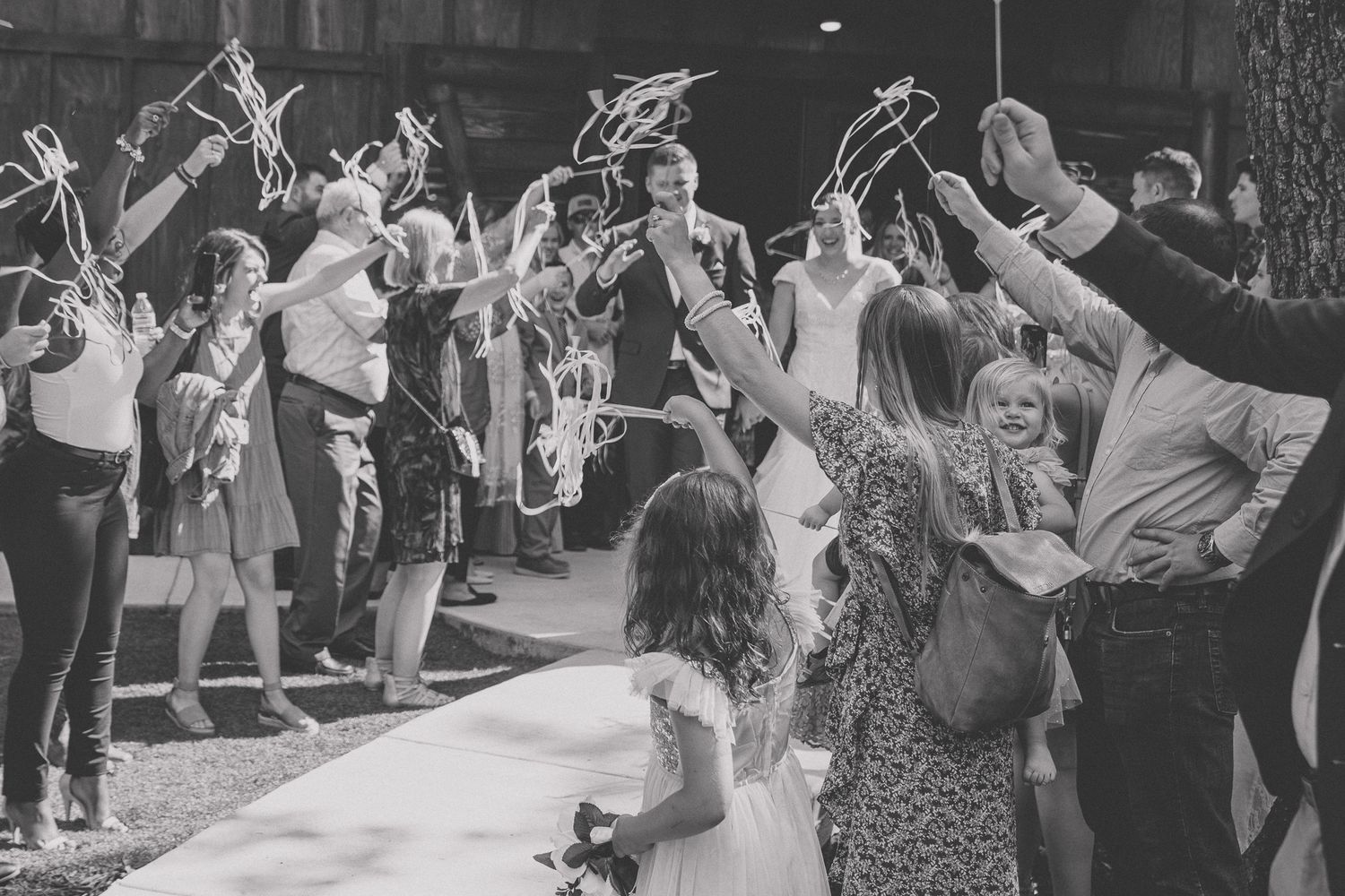A black and white photo montage showing people dancing and celebrating at what appears to be a wedding reception.
