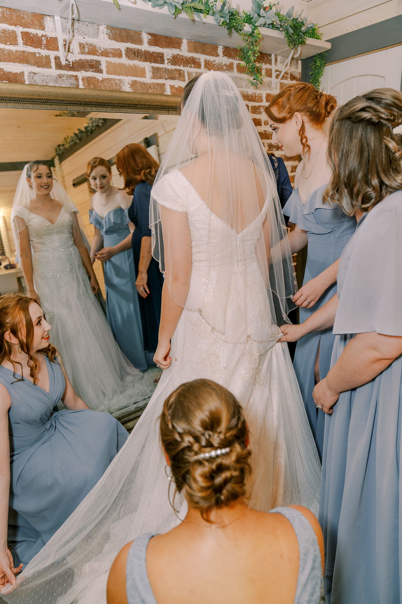 A series of wedding preparation photos showing bridesmaids in dusty blue dresses helping with the bride's gown.