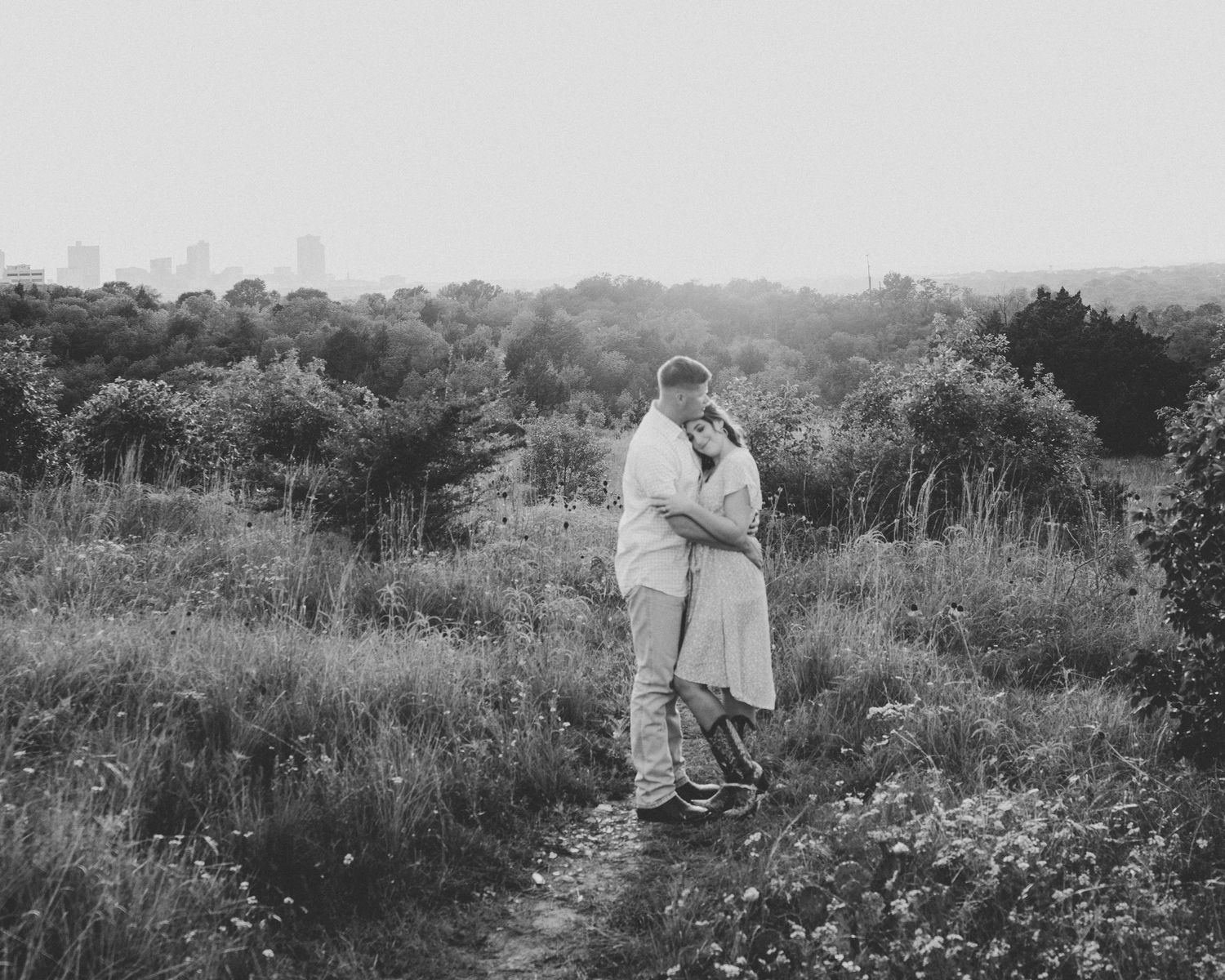 A couple shares an intimate moment in a wildflower meadow at sunset.