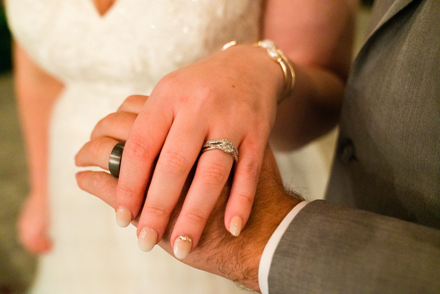 Close-up shots of wedding rings and hands showing the newlyweds' jewelry details.