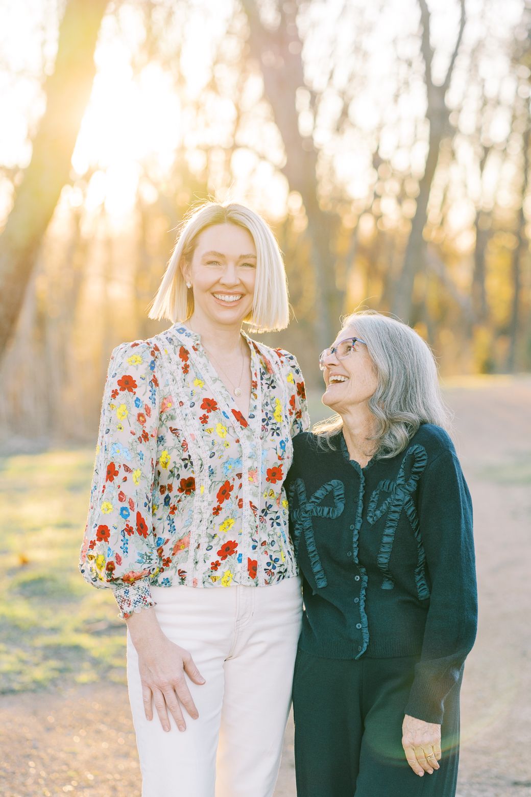 Two people share joyful moments together outdoors during golden hour in a natural setting.