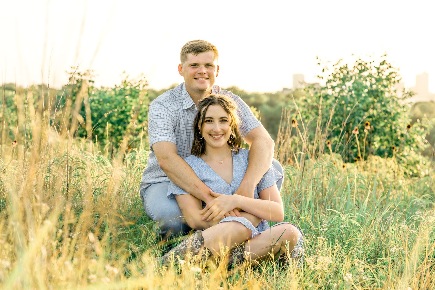 Intimate couple portraits captured in a summer meadow with warm sunset lighting.