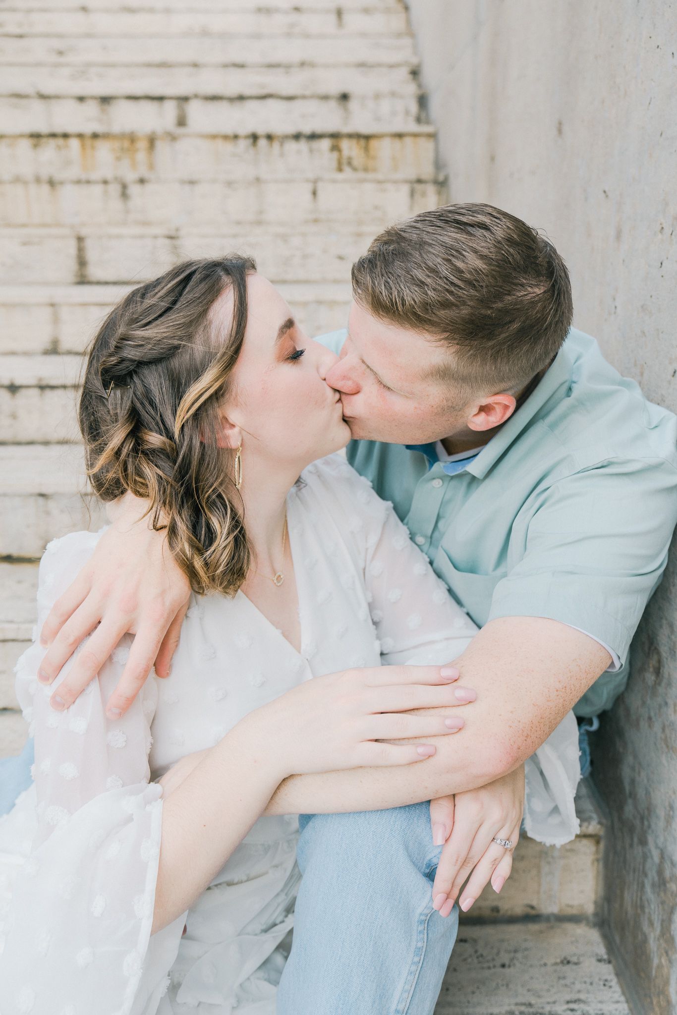 Series of intimate moments between couple against light concrete wall background.