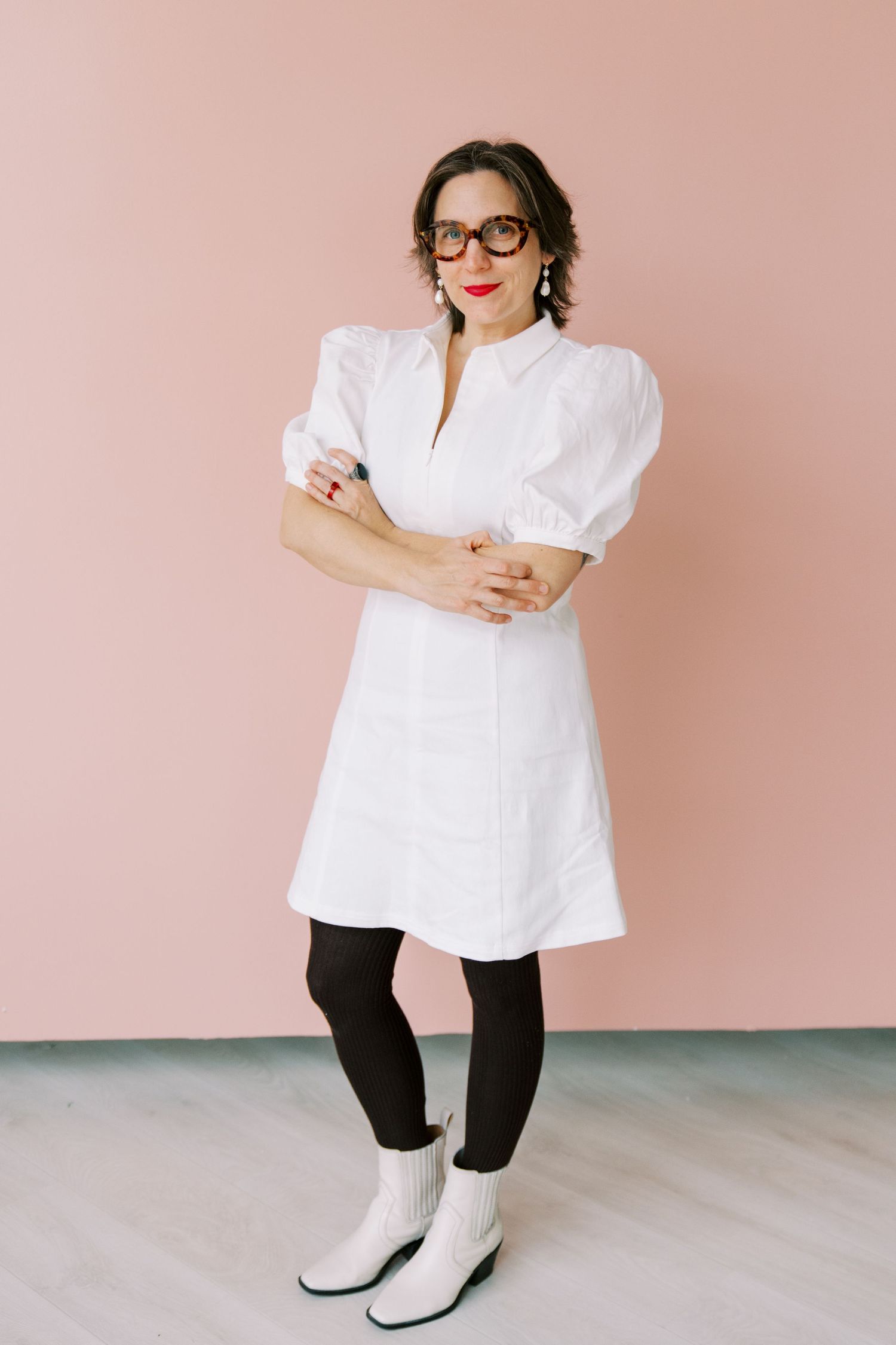 A series of fashion photos showing a white blouse styled with black pants and white boots against a pink backdrop.