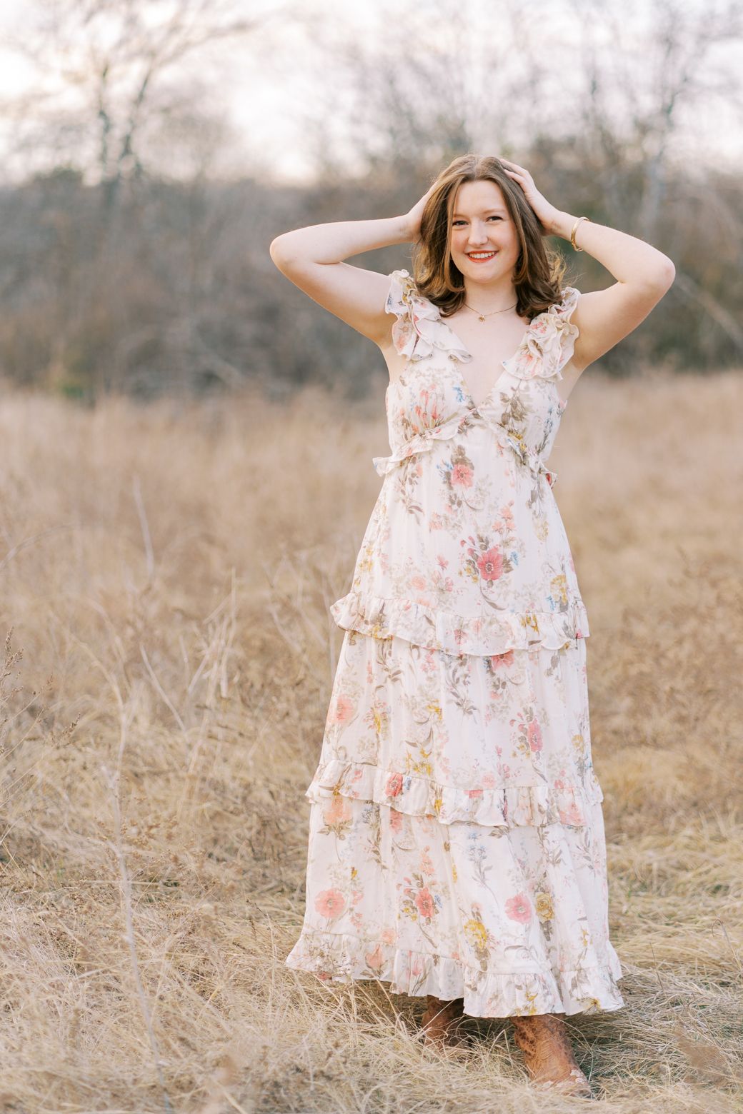 Feminine floral dress with ruffled details captured in a rustic field during golden hour.