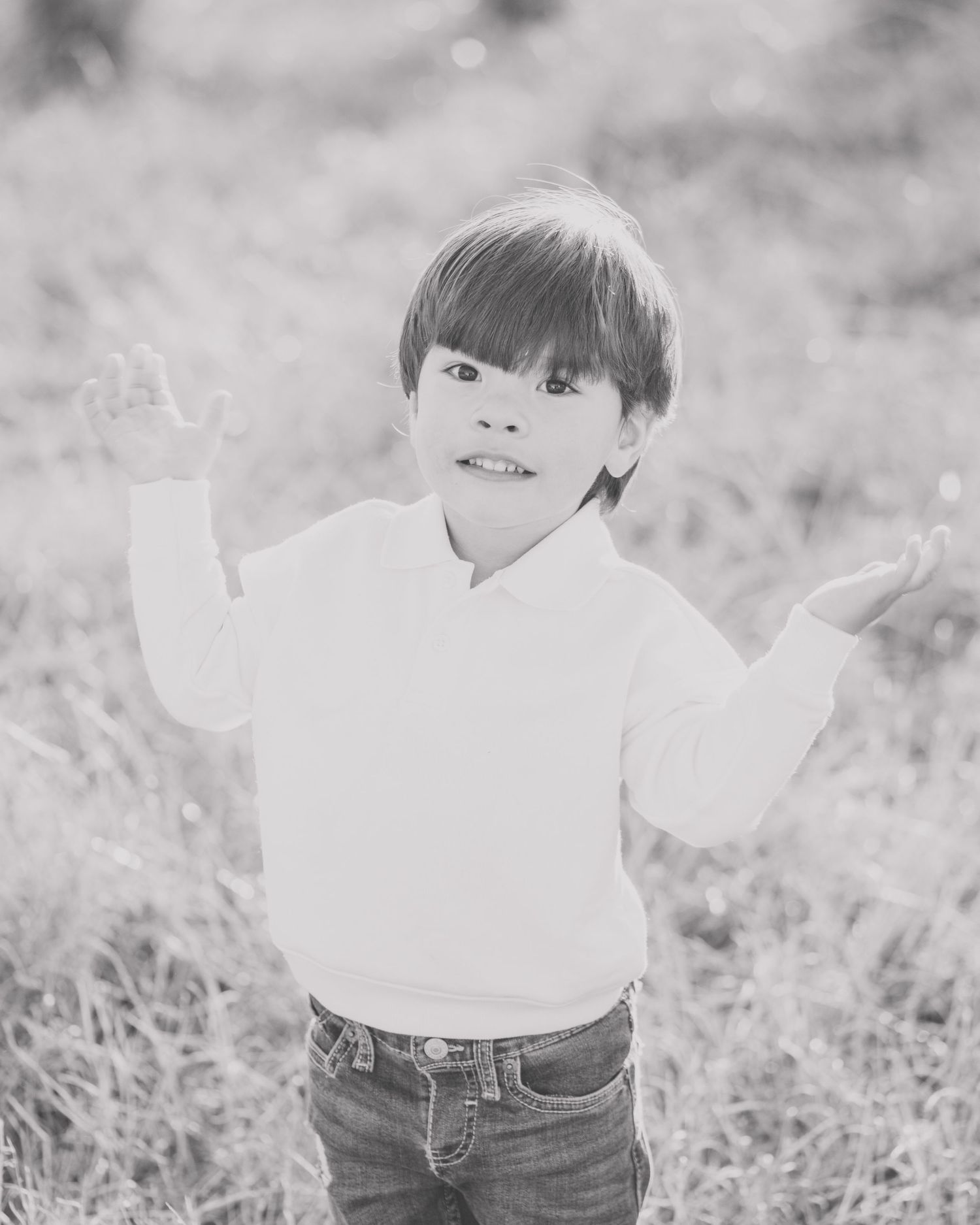 Black and white photo series showing a small child in jeans and white shirt playing outdoors in grassy field.