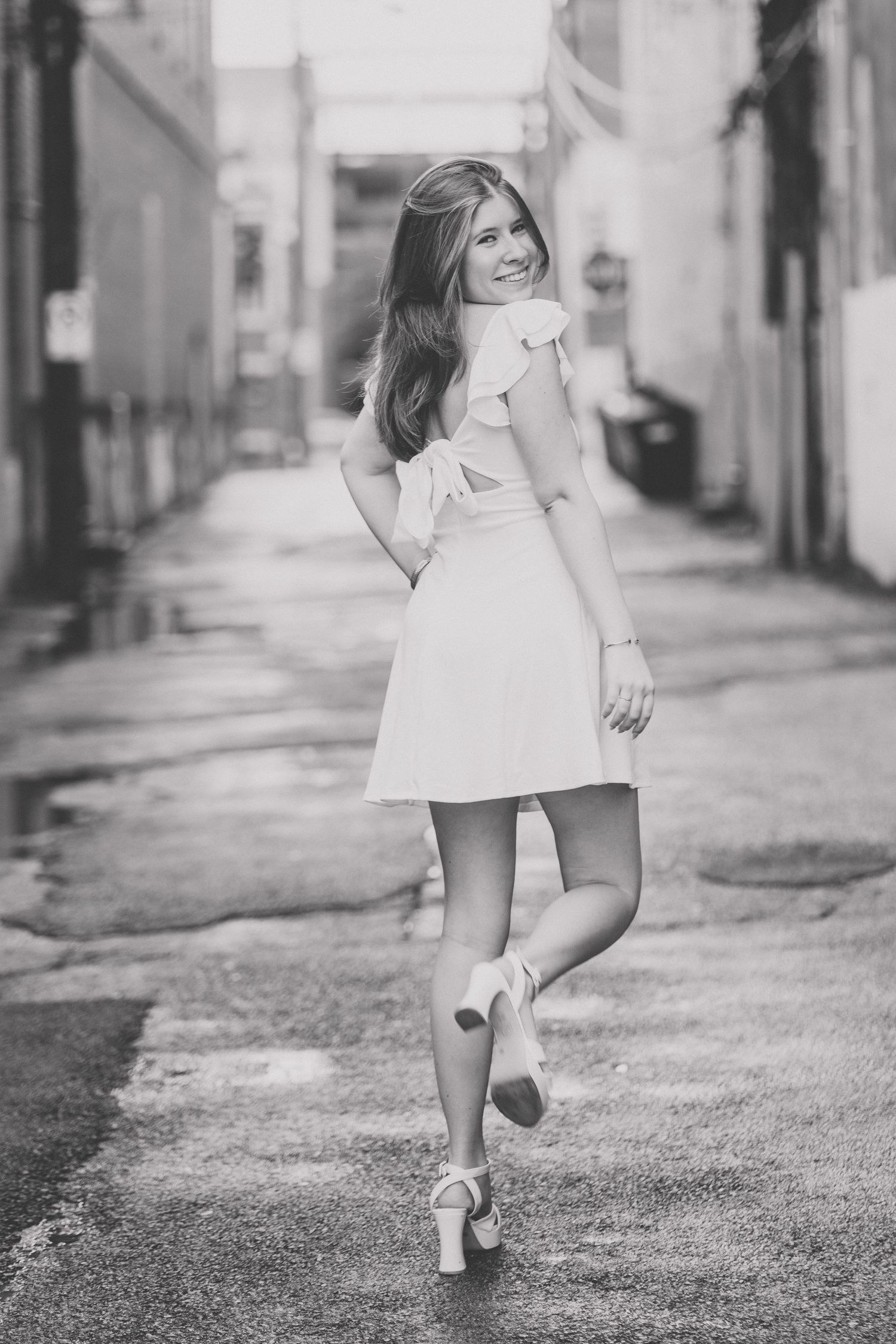 A black and white photo sequence shows legs in white shoes walking on a textured street surface.