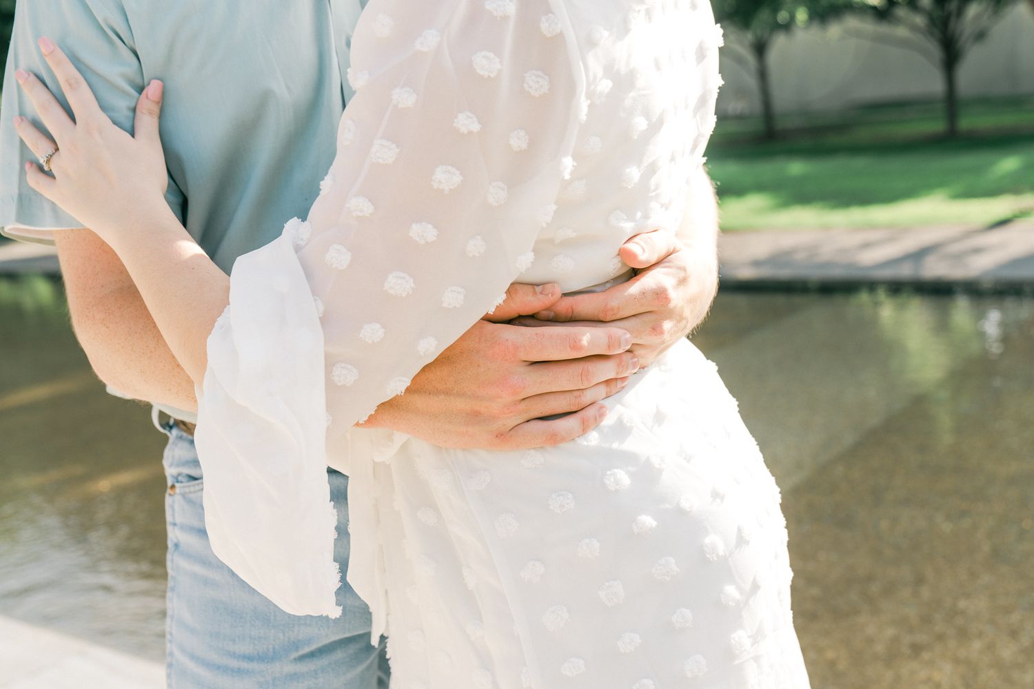 A series of intimate engagement photos showing a couple in light colored clothing by a waterfront.