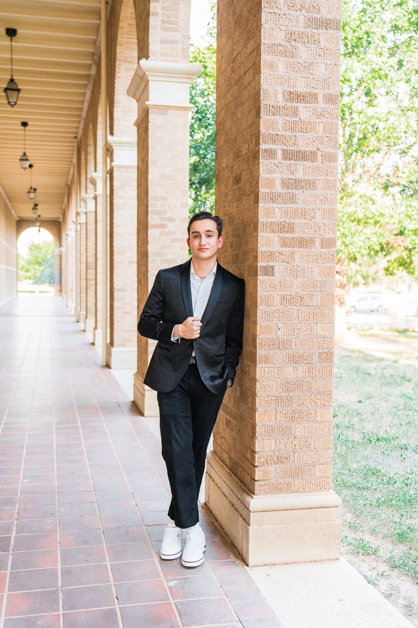 A series of three connected photos showing a person in a black suit walking through a covered brick colonnade walkway.