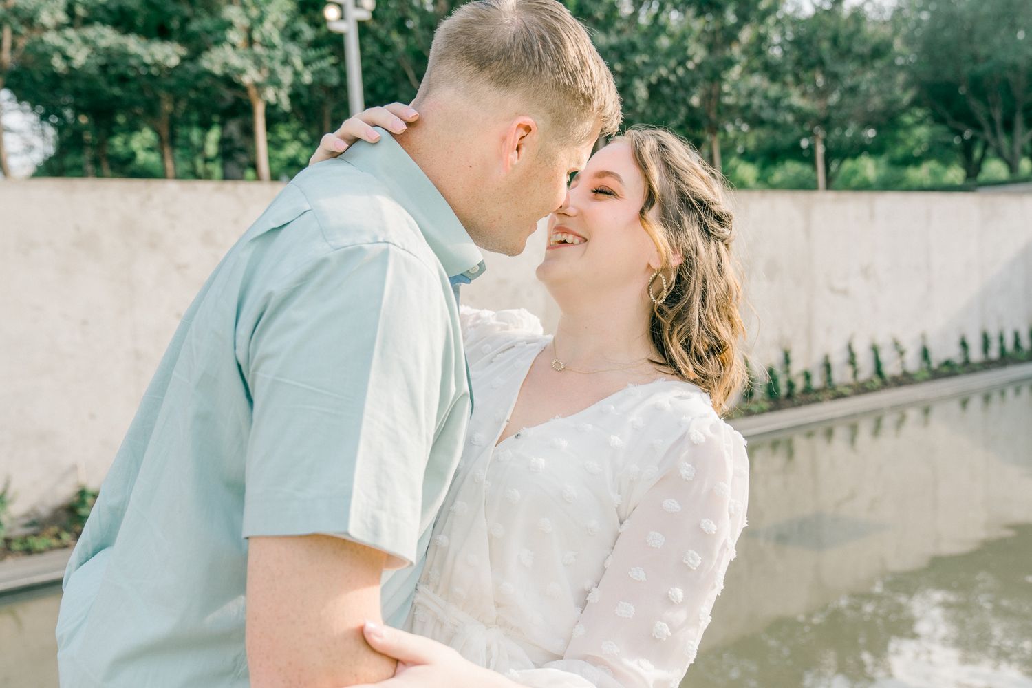 A sweet embrace captured in soft lighting against an outdoor backdrop.