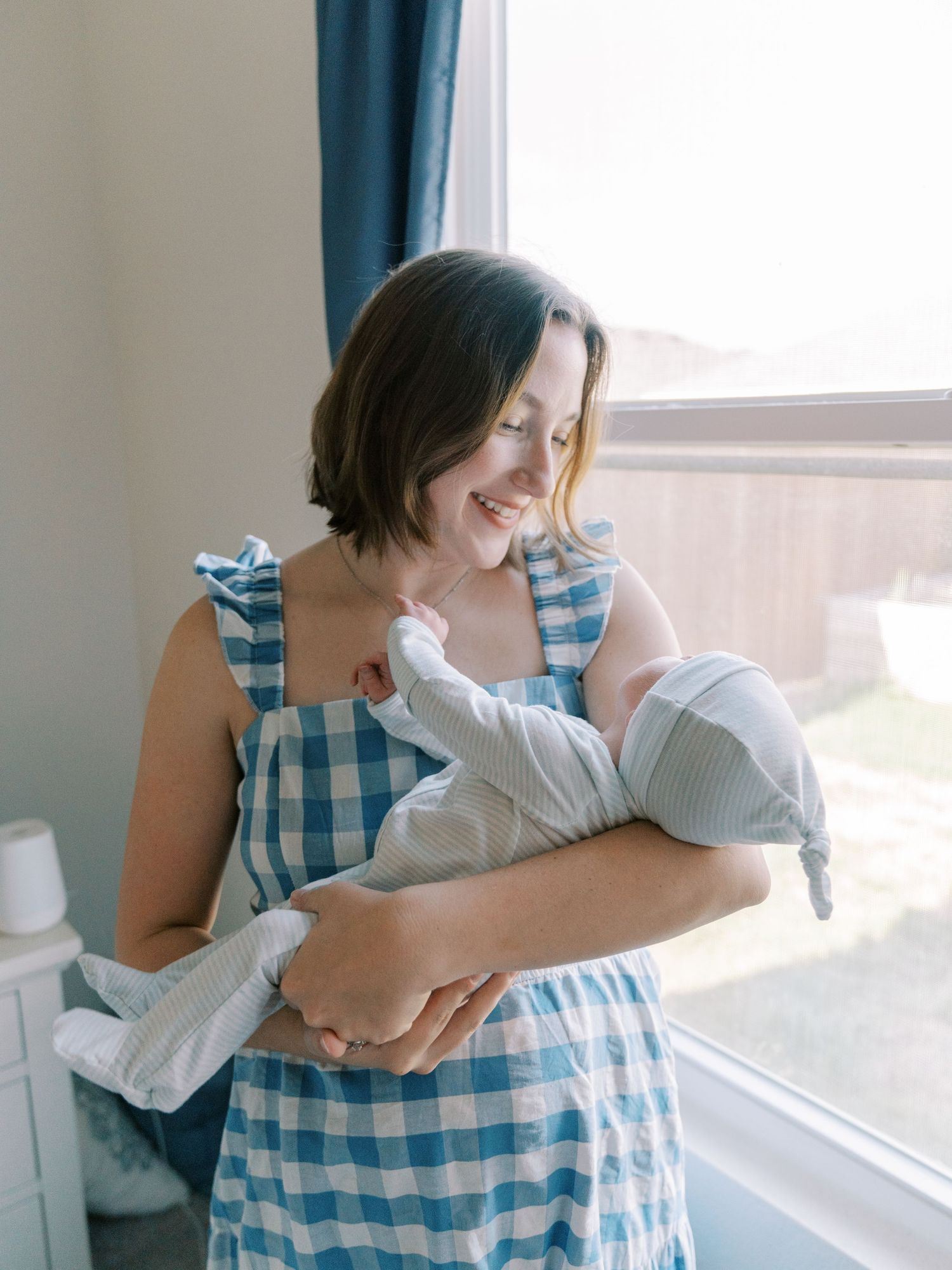 Tender nurturing moment by a sunlit window with soft natural lighting.