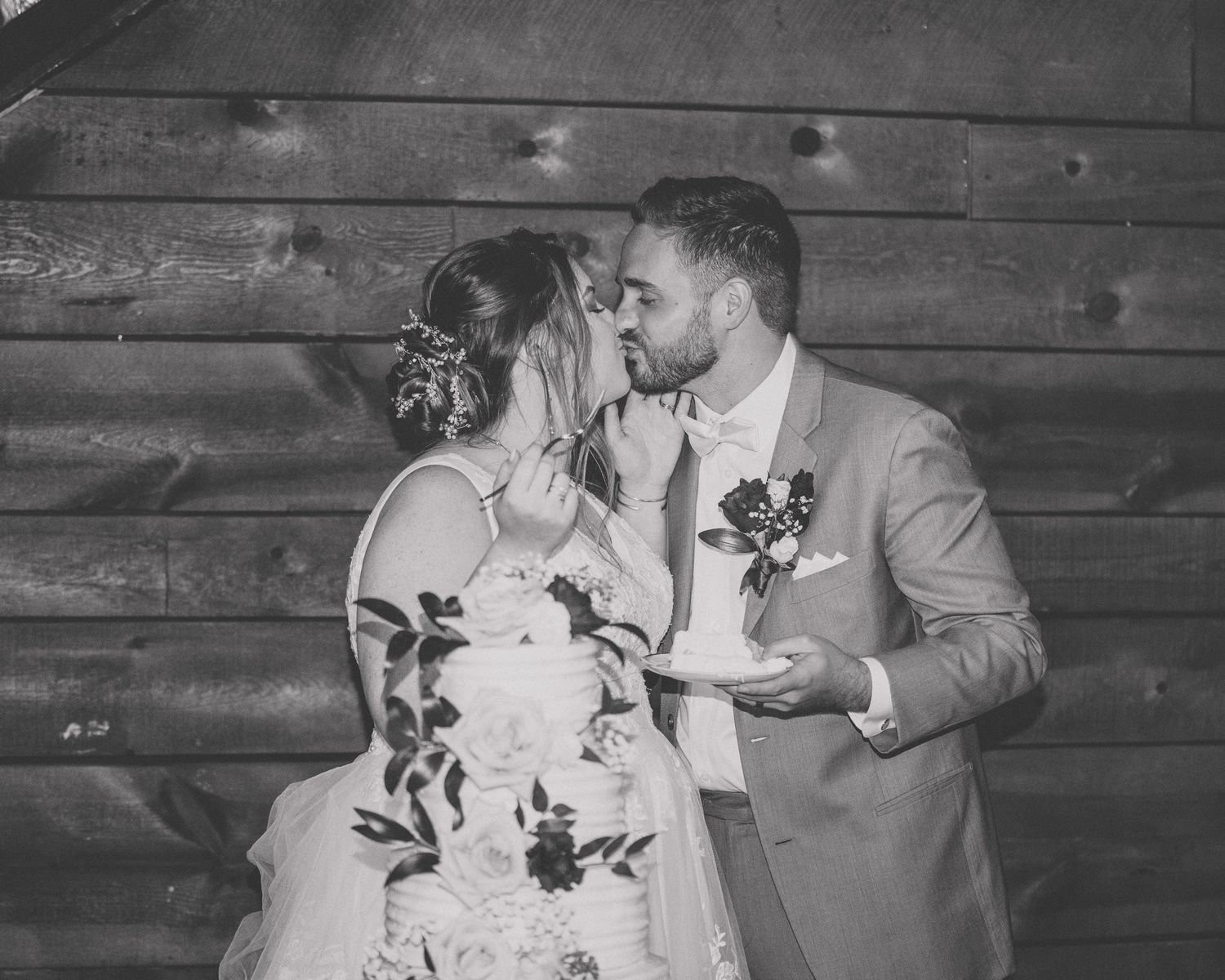 A romantic black and white photo collage showing tender moments between newlyweds against a wooden wall backdrop.