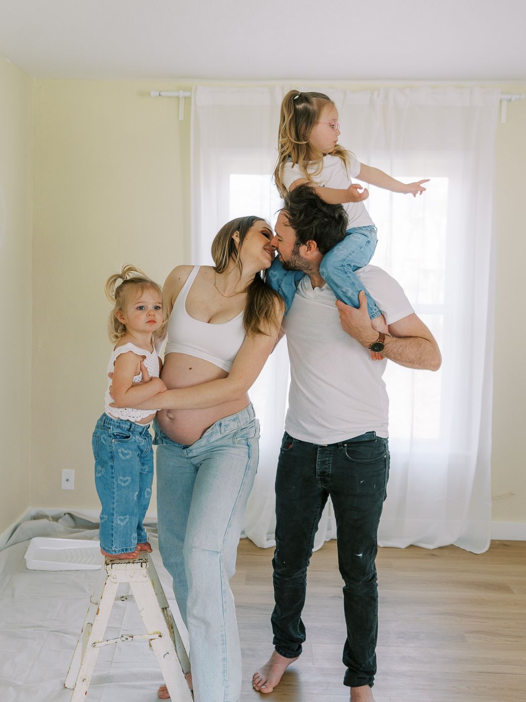 Family members interact while doing home renovation in a bright, minimalist space.