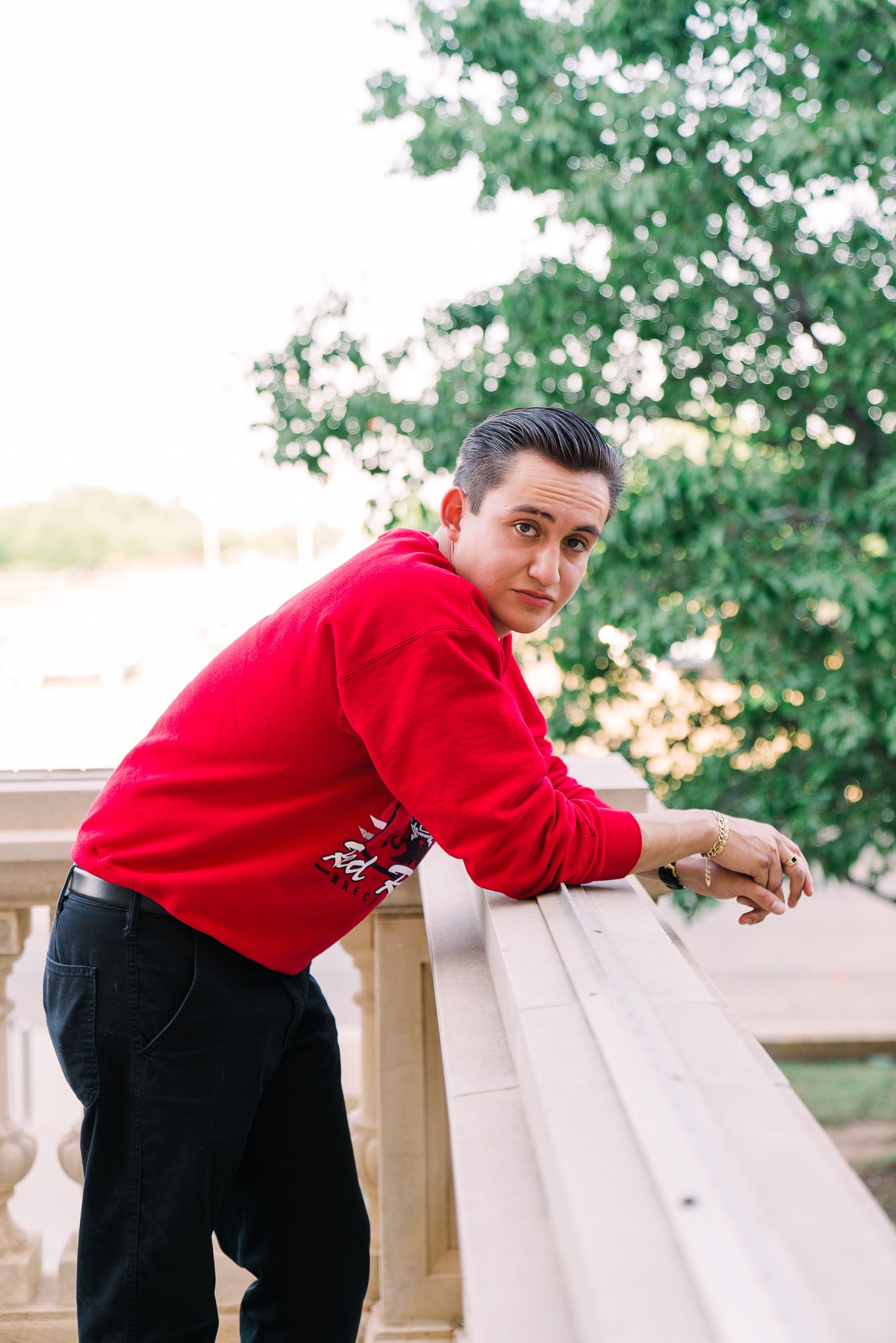 Three sequential shots show someone in a red sweater and black pants leaning over a wooden railing outdoors.