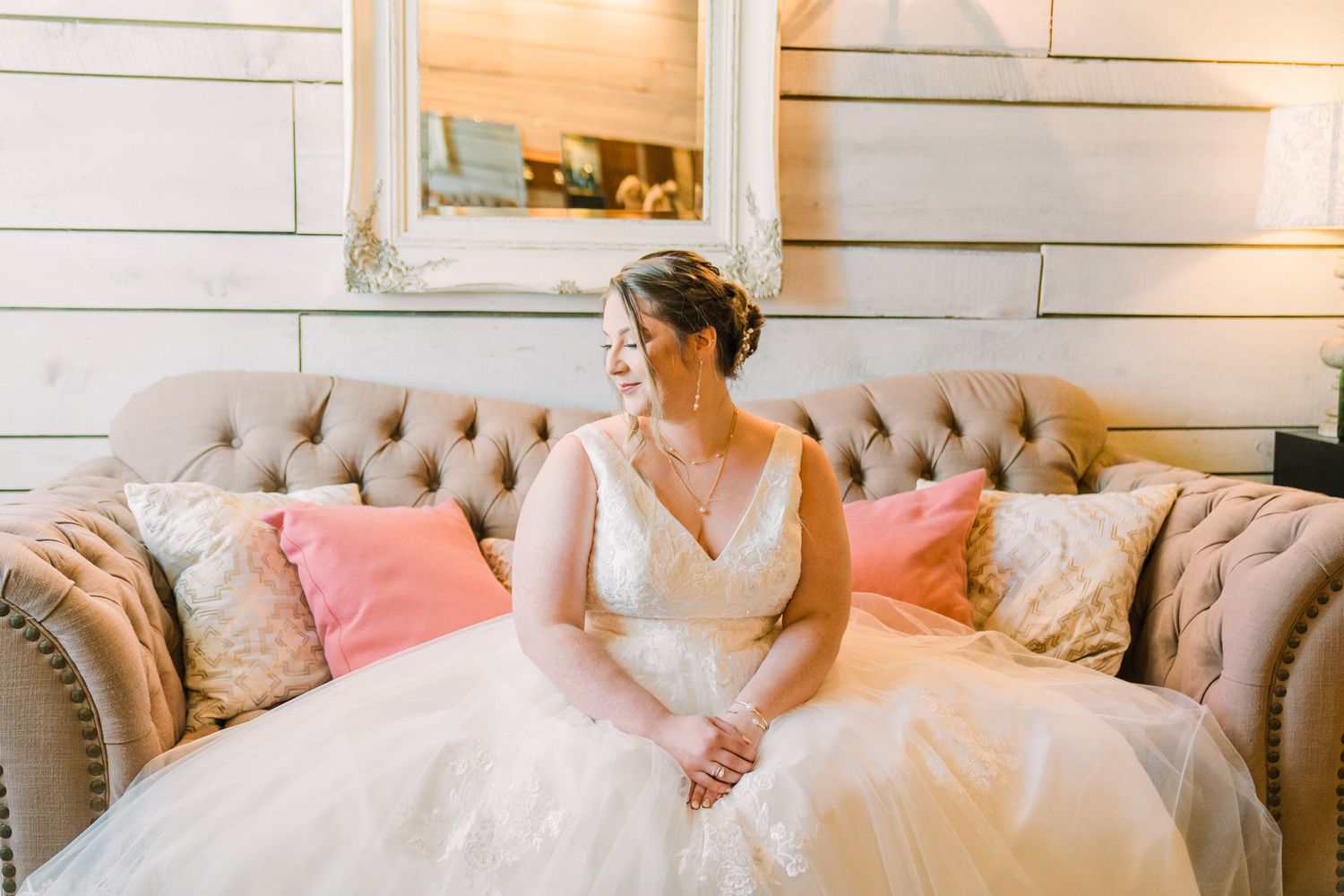 Elegant wedding reception space with pink and white decor and tufted seating.