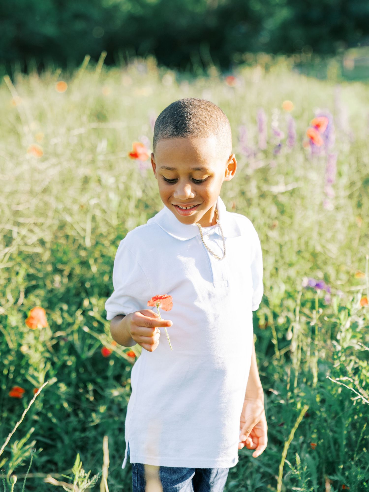 A child in a white shirt explores a vibrant wildflower meadow on a sunny summer day.