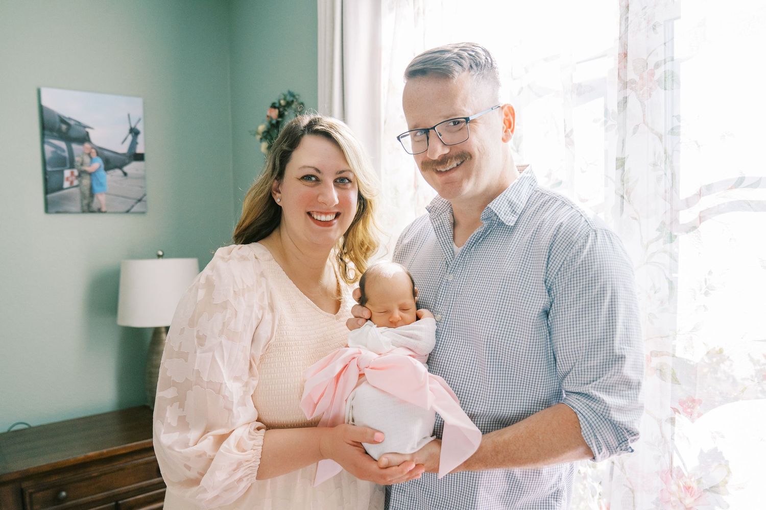 Family spending quality time together on a mint green couch in a bright, sunlit room.