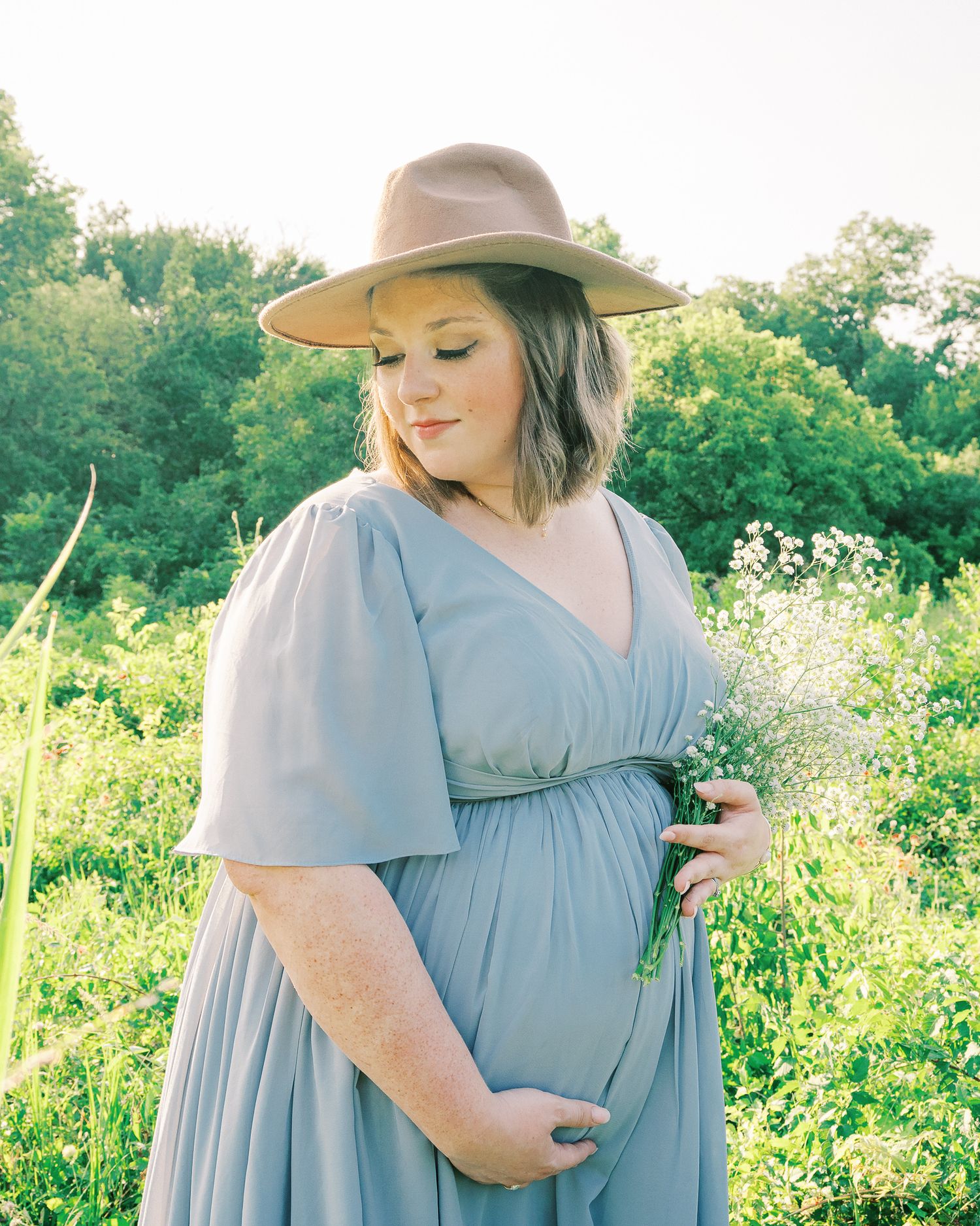 A dreamy outdoor maternity photoshoot in a field of wildflowers during golden hour.