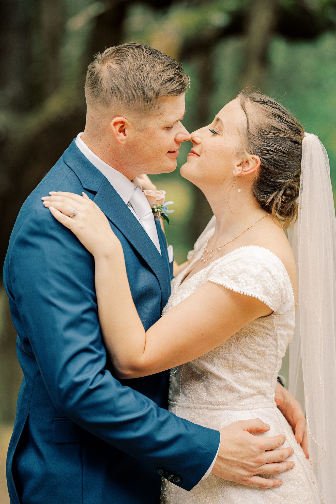 Romantic wedding sequence shows couple in navy suit and white dress sharing intimate kisses during outdoor photo session.