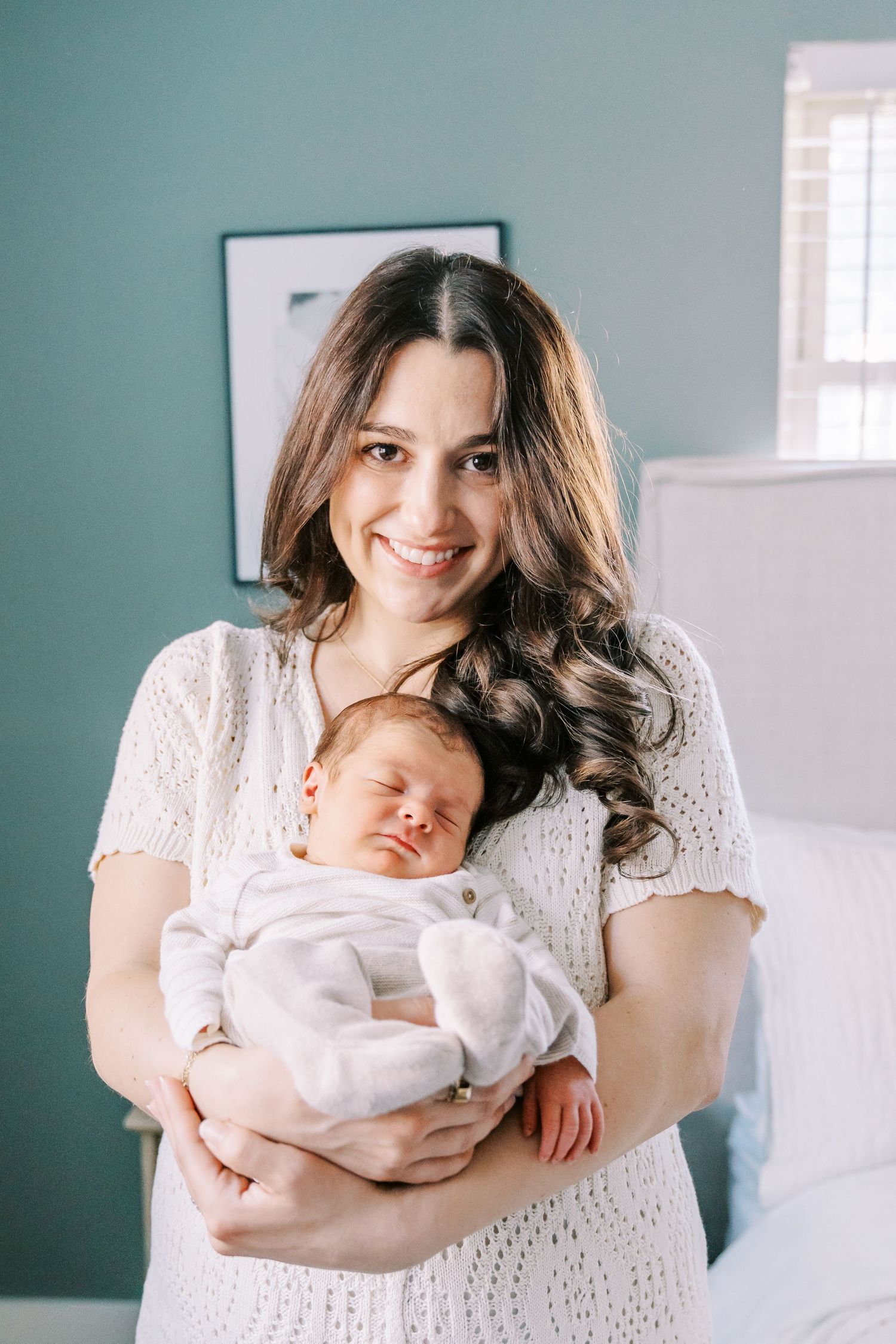 A series of intimate newborn photos showing tender moments between parent and baby against a soft teal wall background.